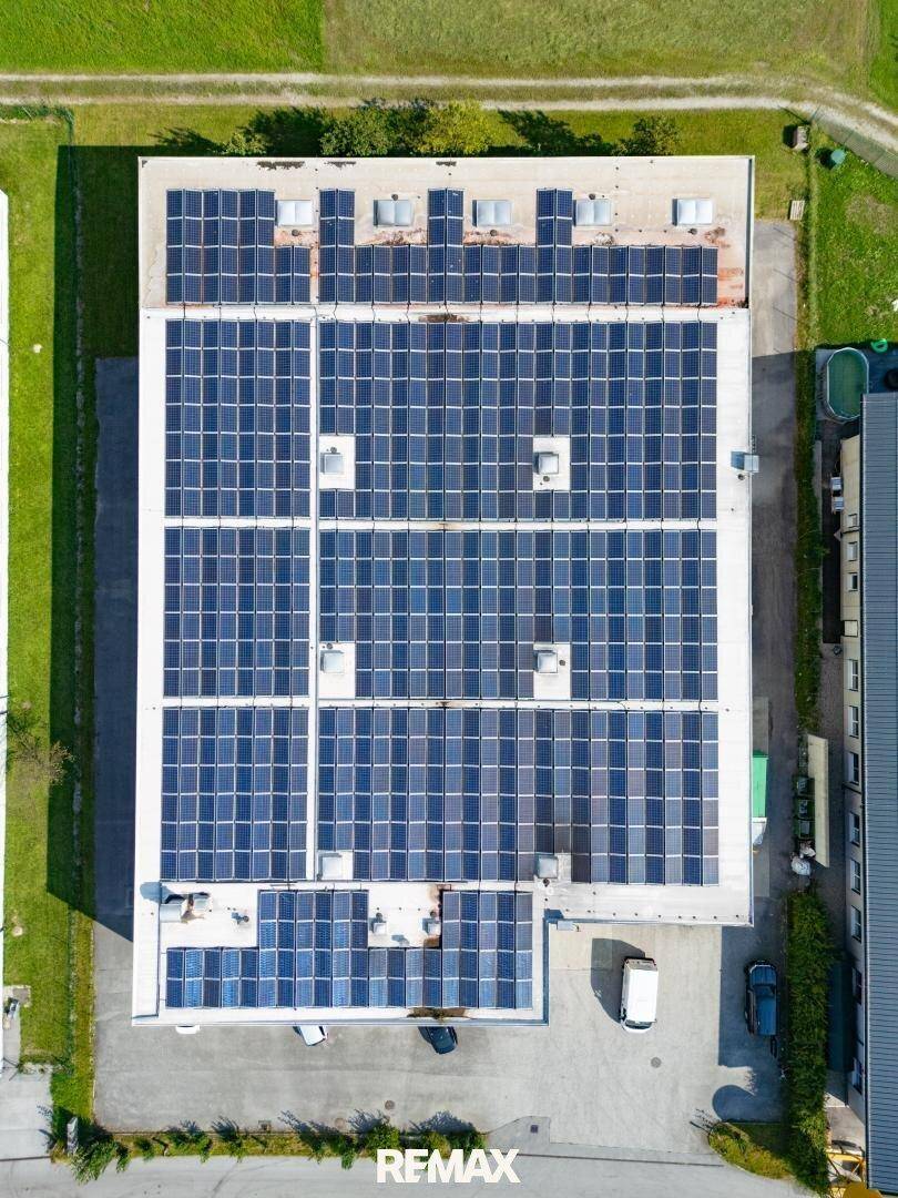 Dachansicht eines Gewerbegebäudes mit zahlreichen Photovoltaik-Modulen zur Energiegewinnung.
