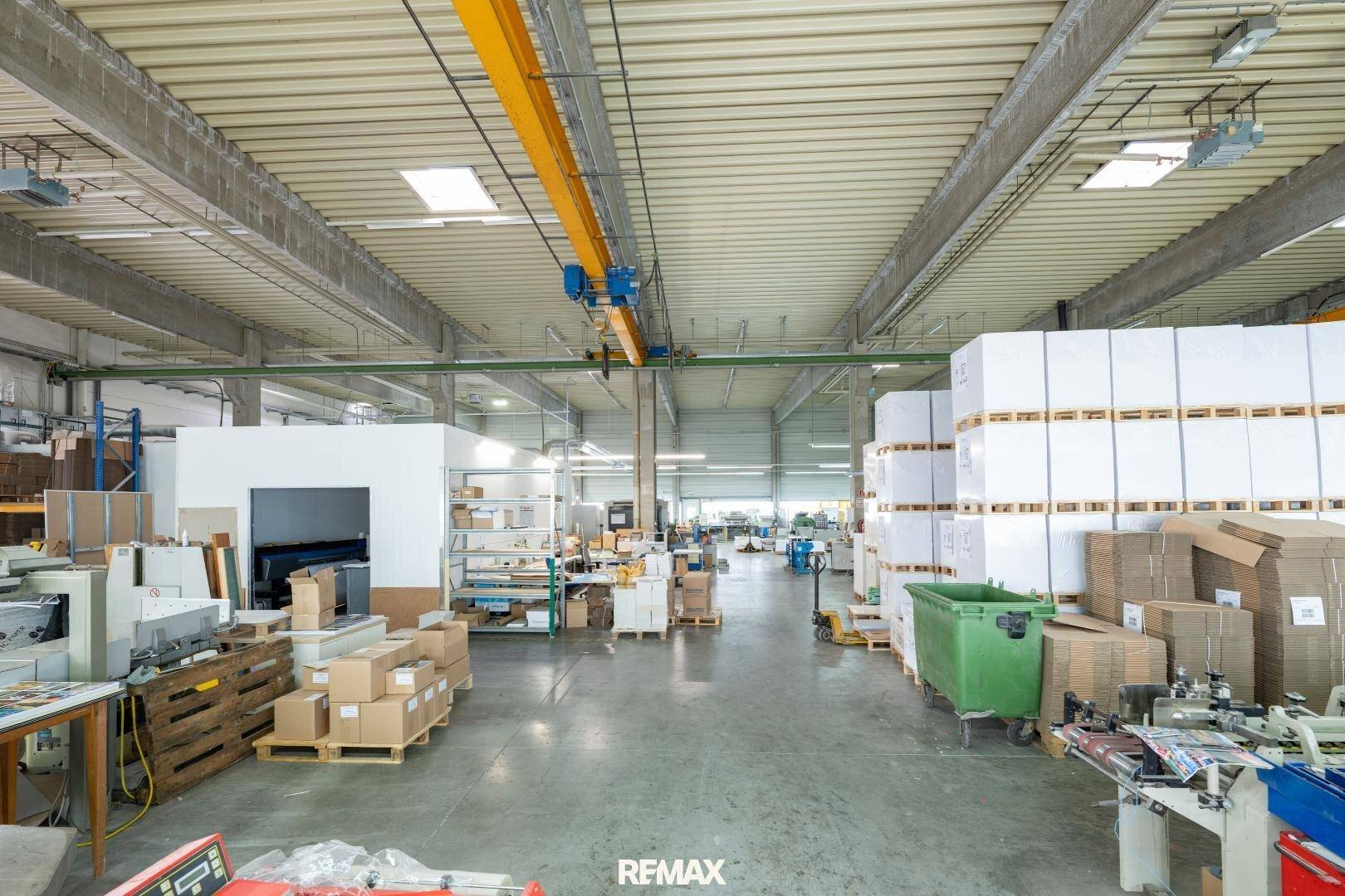 Großer Produktionsbereich mit integriertem Büro, Lagerflächen und verschiedenen Maschinen.