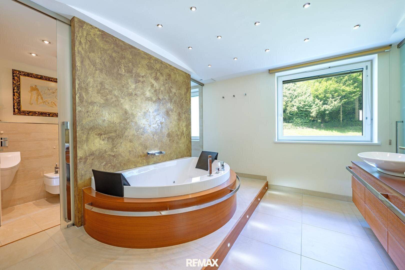 Modernes Badezimmer mit Whirlpool-Badewanne, Doppelwaschbecken und Fenster.