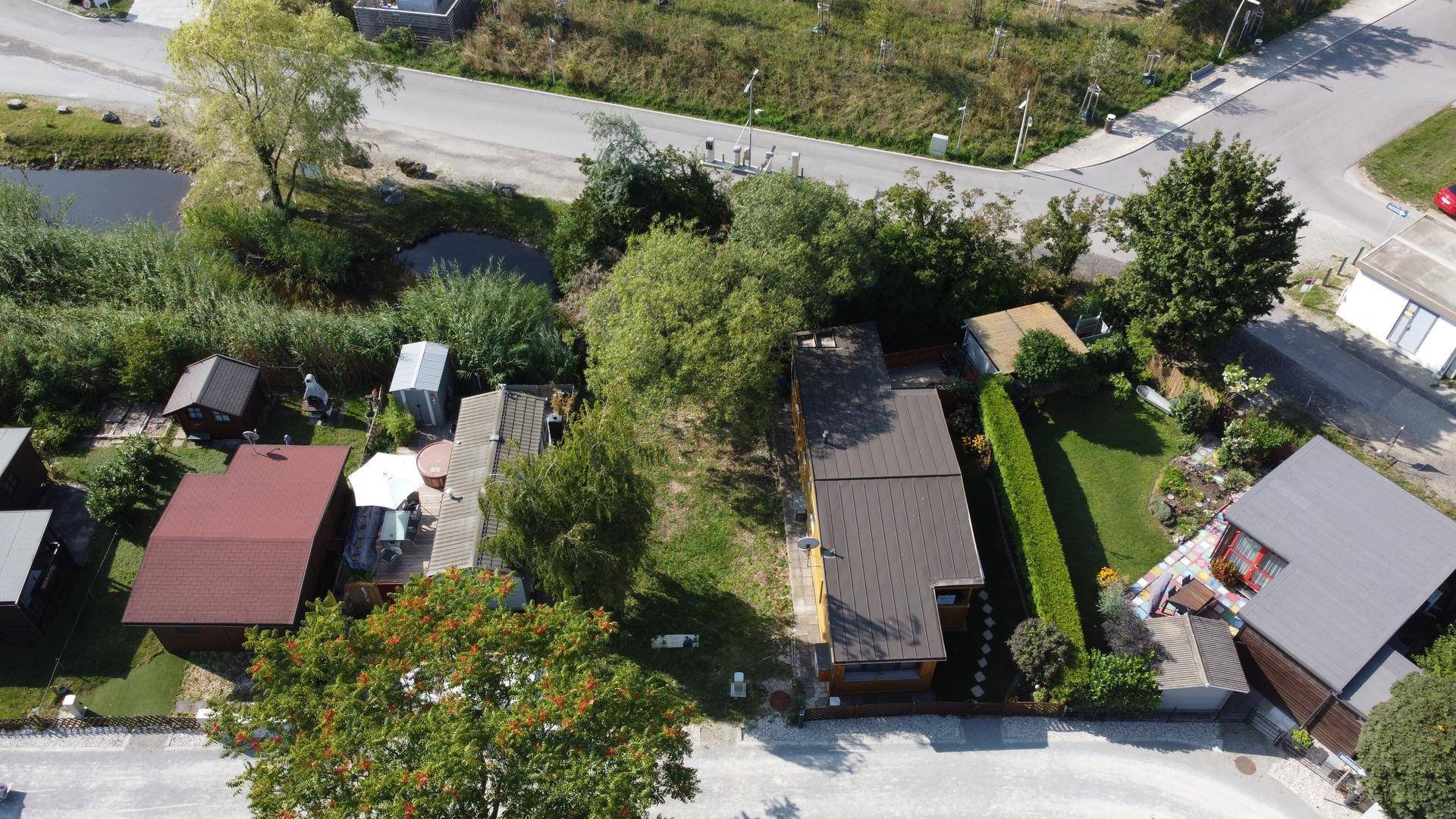 Übersicht aus der Vogelperspektive einer Wohnanlage mit Häusern, Gärten und Wegen.