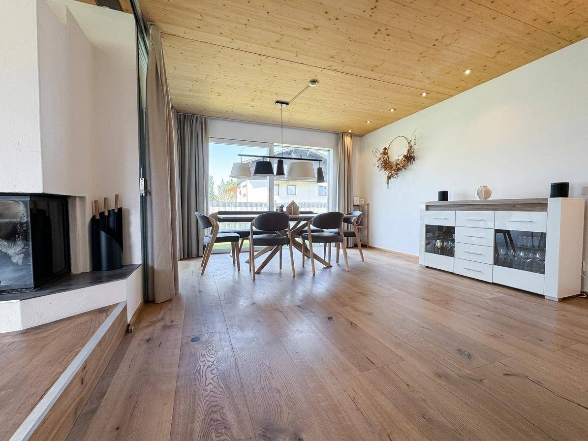 Heller Essbereich mit Holztisch, modernen Stühlen und Zugang zum Garten durch große Fenster.