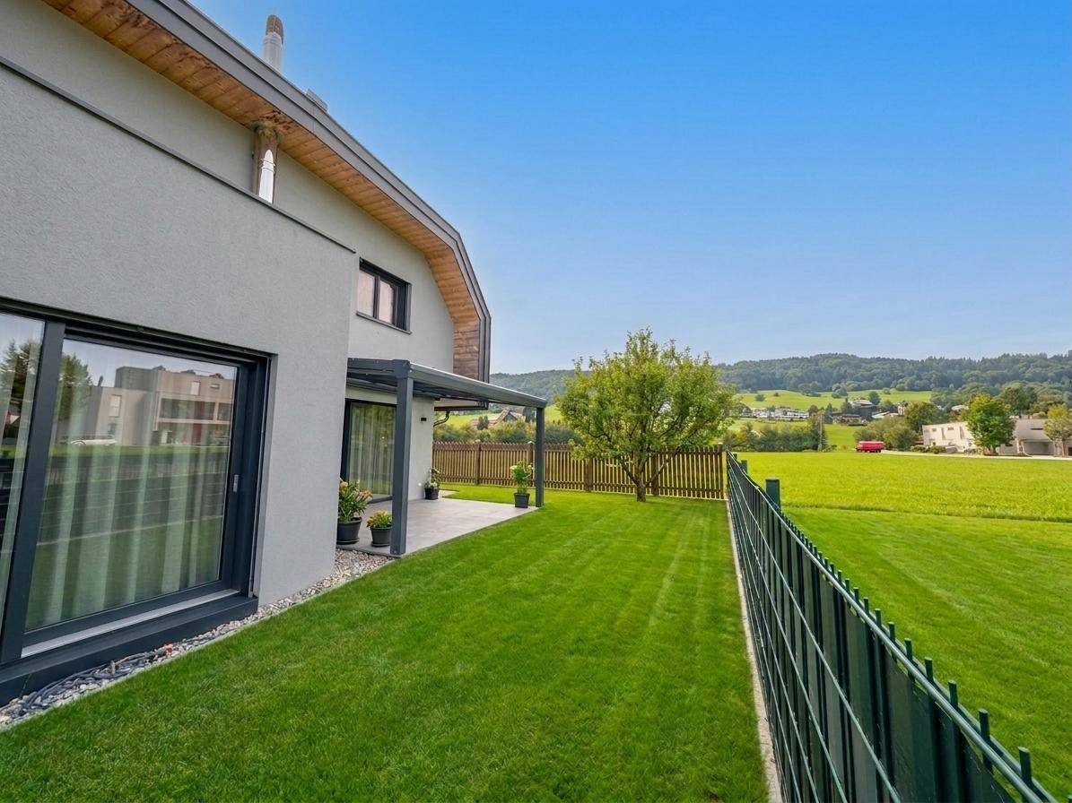 Gepflegter Gartenbereich mit Rasenfläche und weitem Blick auf die umliegende Landschaft.