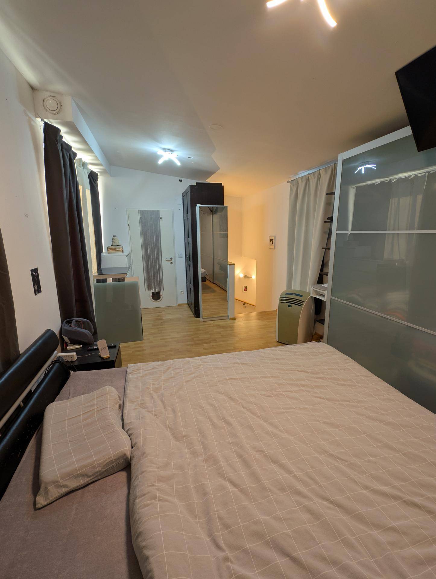 Geräumiges Schlafzimmer mit Doppelbett und großem Kleiderschrank mit Spiegeltüren.