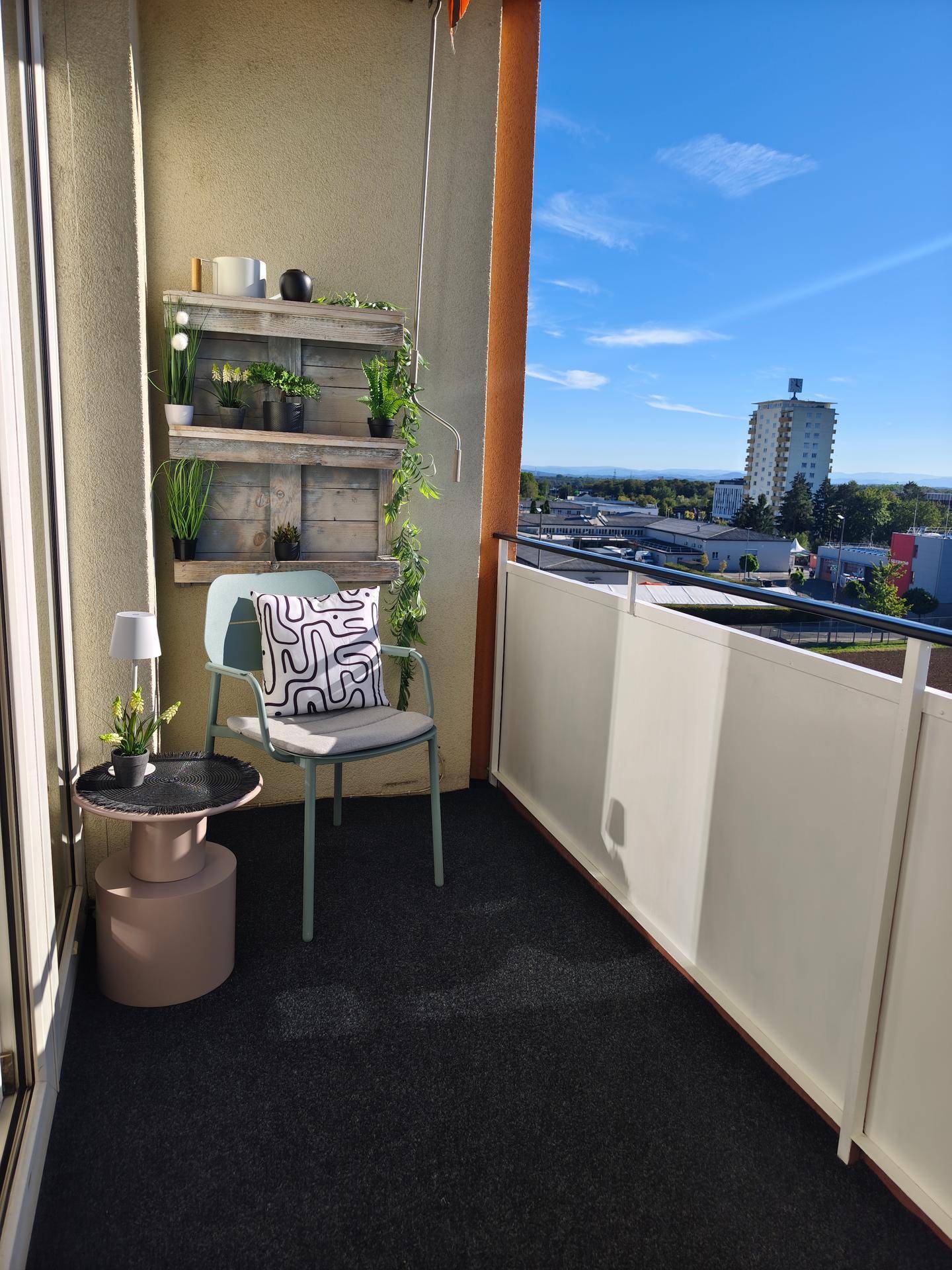 Sonniger Balkon mit Sitzgelegenheiten und weitem Blick über die Stadt und Umgebung.