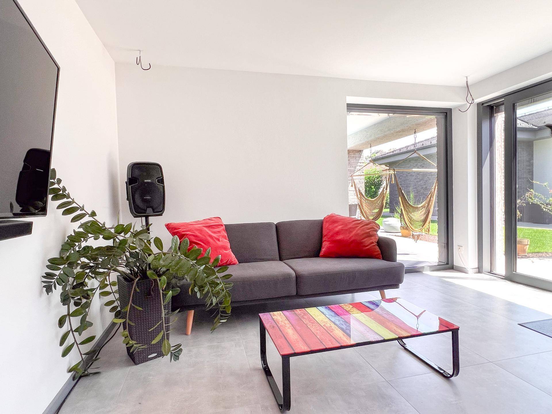 Gemütlicher Wohnbereich mit Sofa, Couchtisch und Zugang zum Außenbereich.