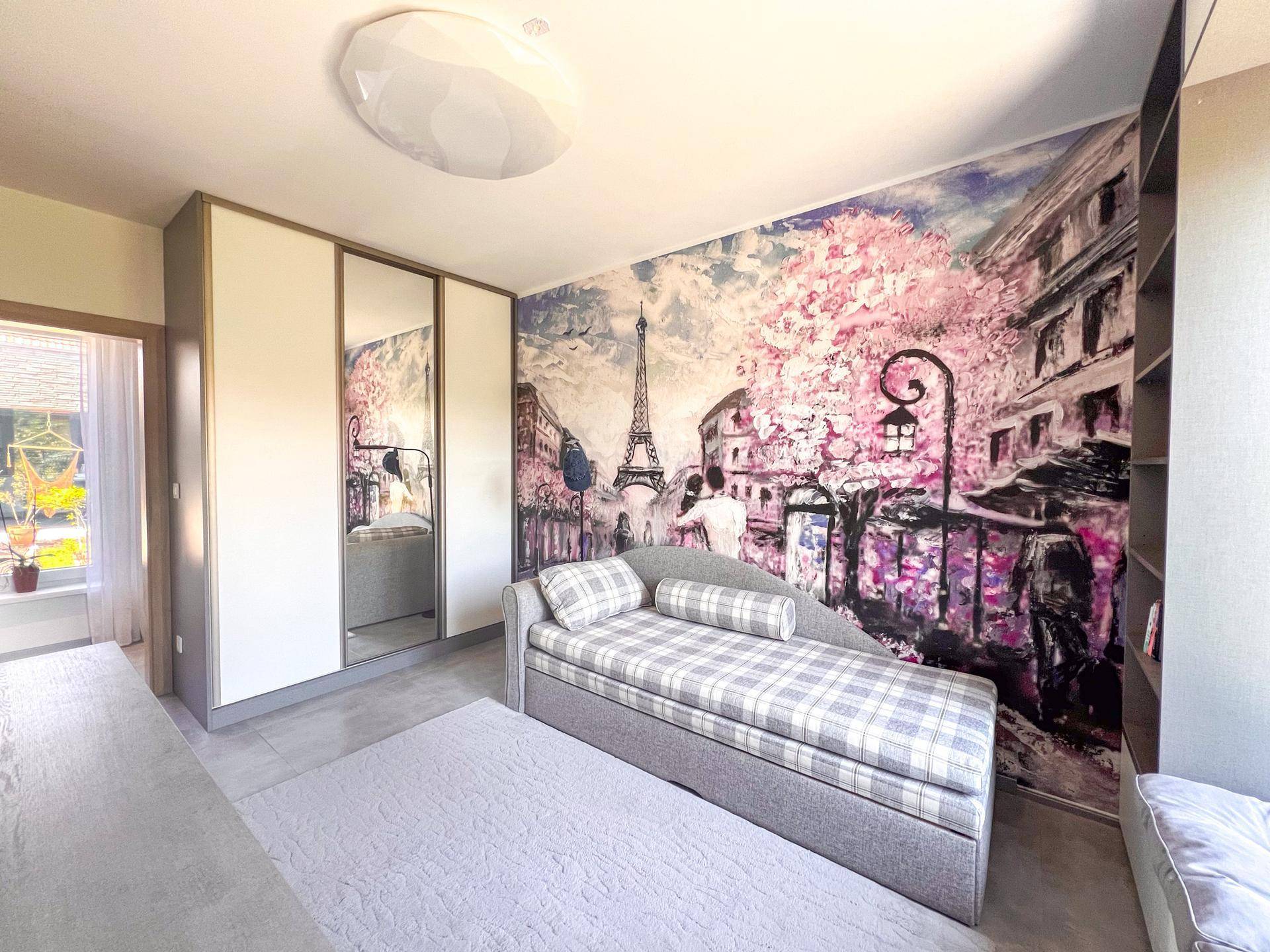 Helles Schlafzimmer mit Pariser Wandtapete, integriertem Kleiderschrank und Tagesbett.