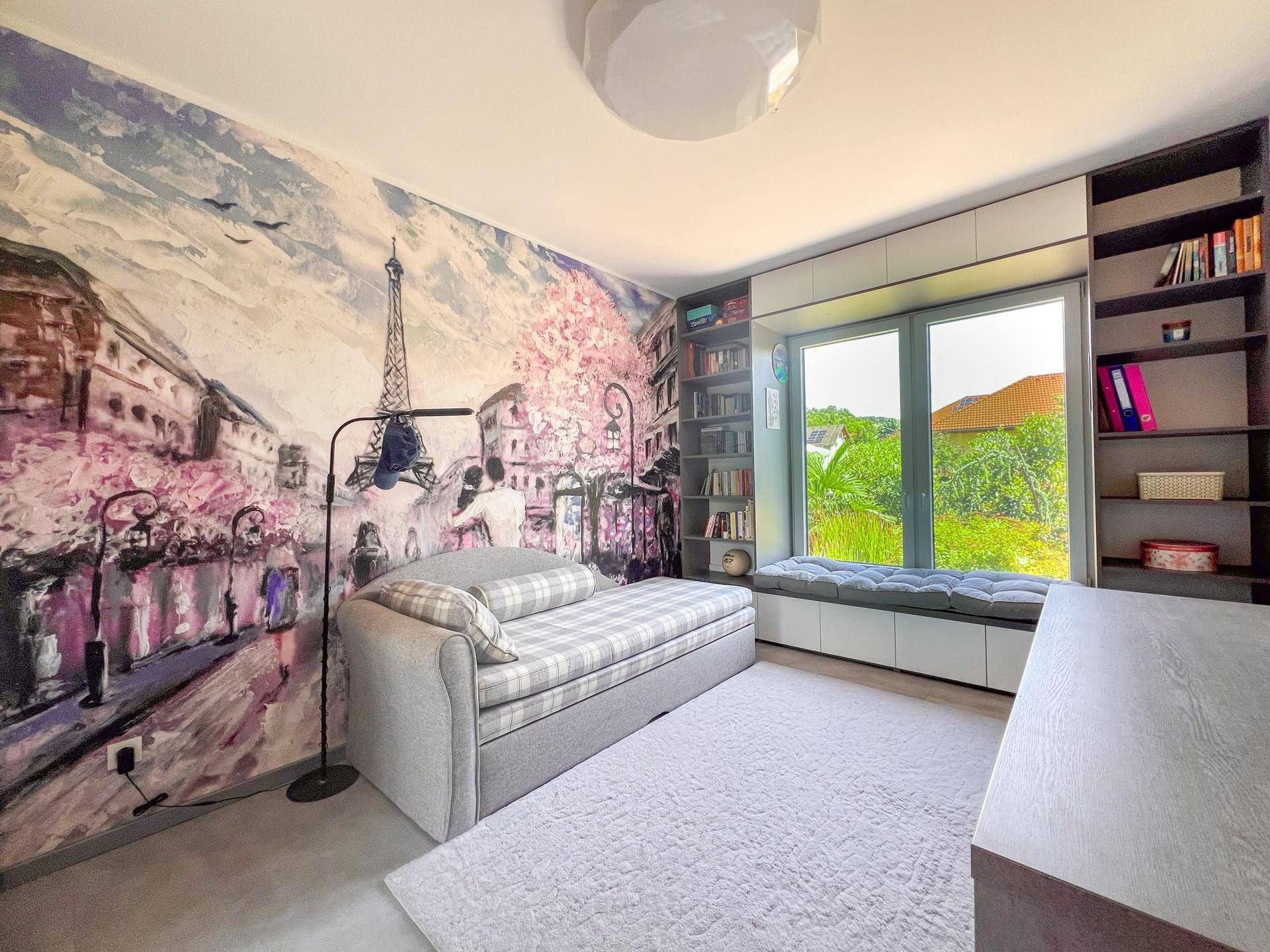 Gemütliches Schlafzimmer mit Tagesbett, Wandtapete und Fensterbank als Sitzgelegenheit.