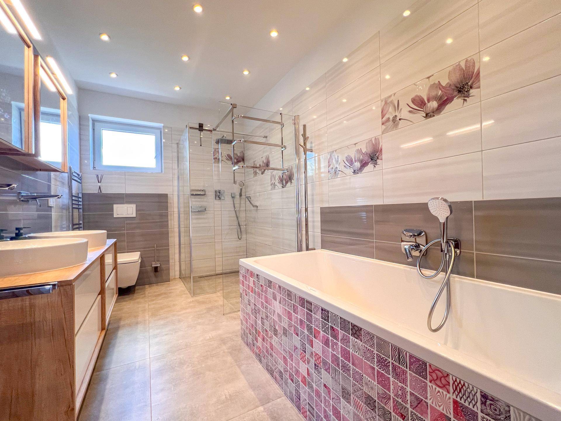 Modernes Badezimmer mit Doppelwaschbecken, Badewanne und großer Dusche.