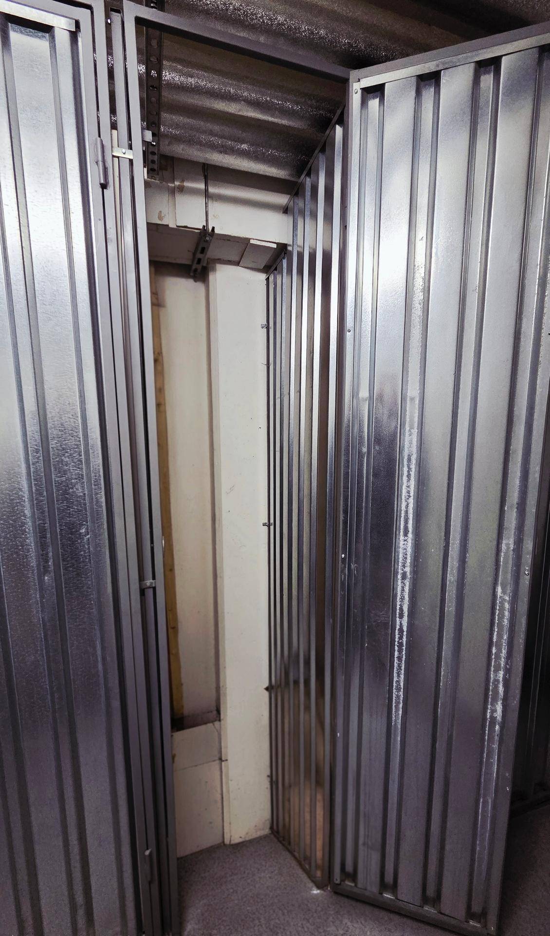 Praktische Abstellräume im Keller mit Metallwänden für zusätzlichen Stauraum.