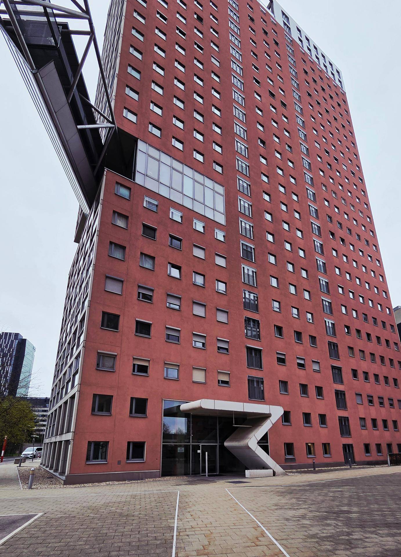 Hohes modernes Gebäude mit markanter Architektur und zahlreichen Fenstern.