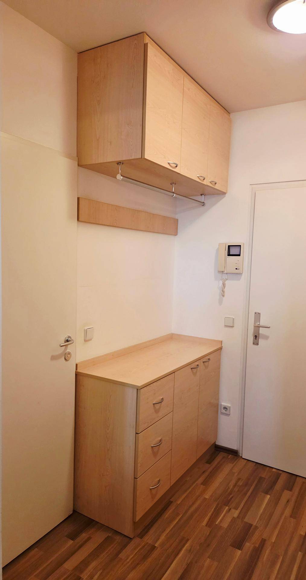 Flur mit praktischen Holzschränken und Ablageflächen für zusätzlichen Stauraum.