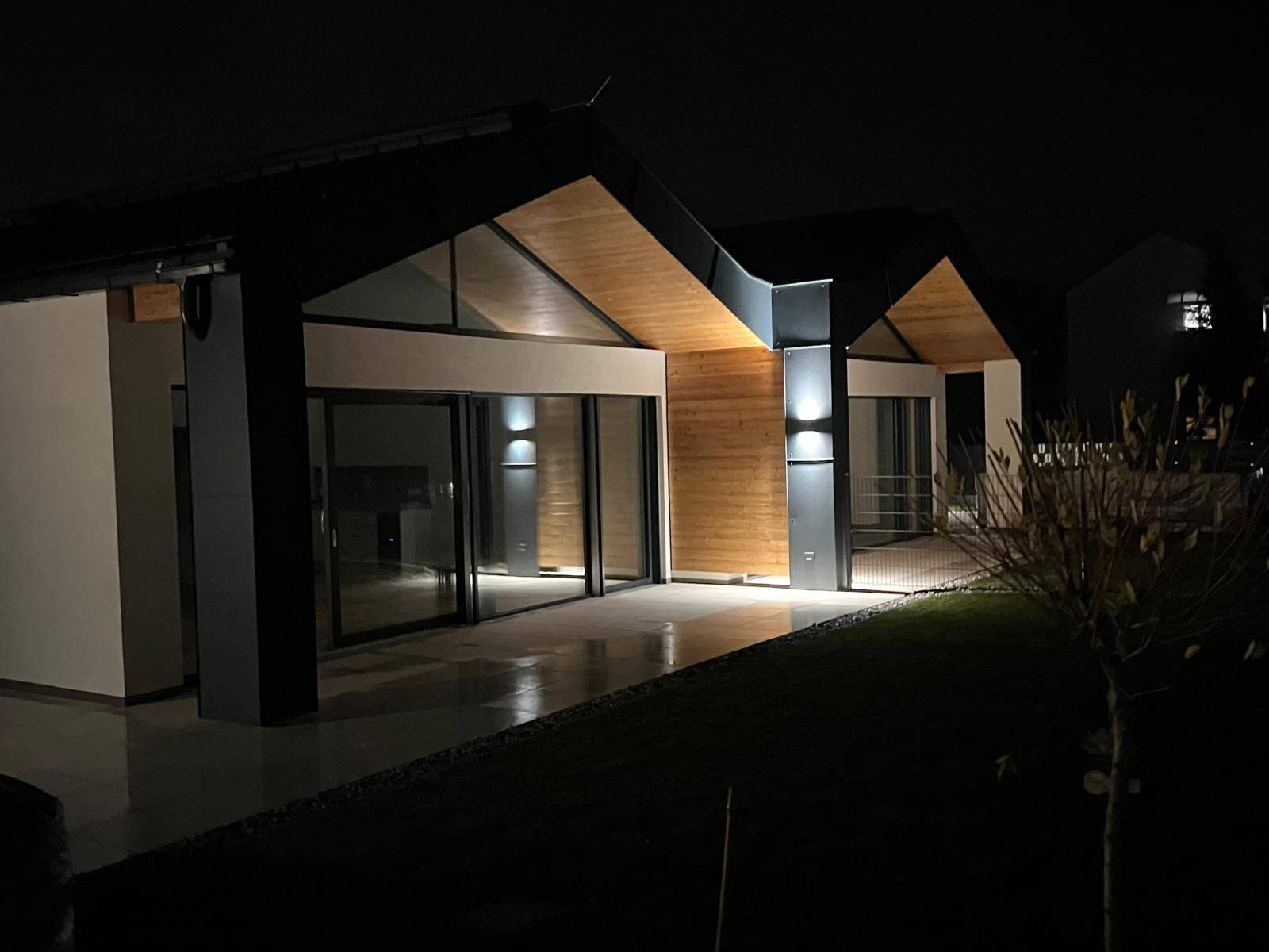 Moderne Gebäudeansicht bei Nacht, beleuchtet mit warmem Licht und klaren Linien.