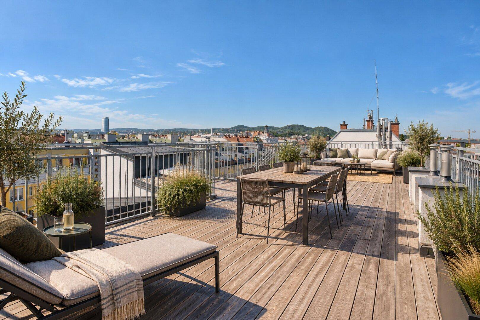 Geräumige Dachterrasse mit Sonnenliege, Esstisch und Panoramablick auf die umliegende Landschaft.