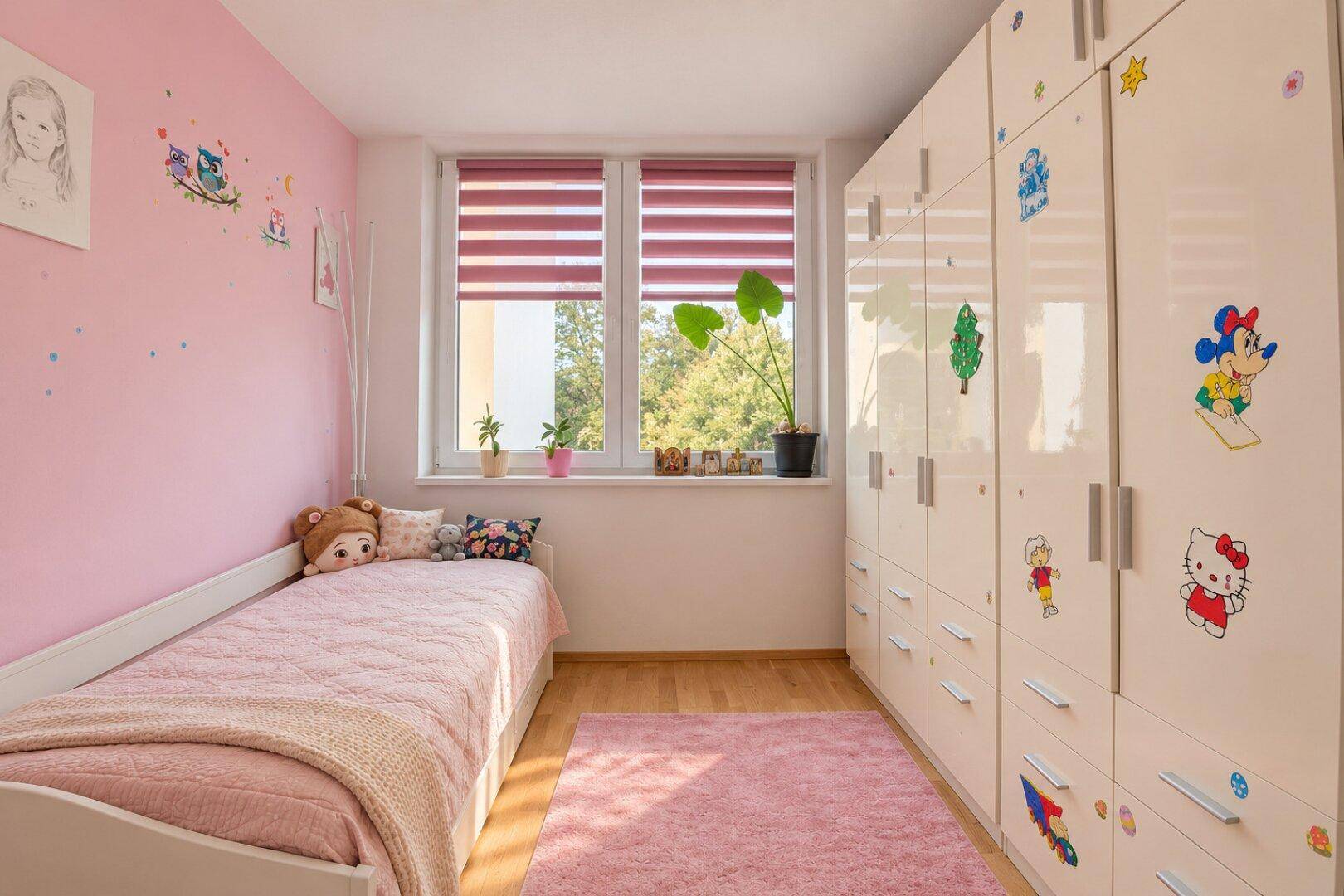 Kinderzimmer mit rosa Wänden, Einzelbett und großem weißen Kleiderschrank.