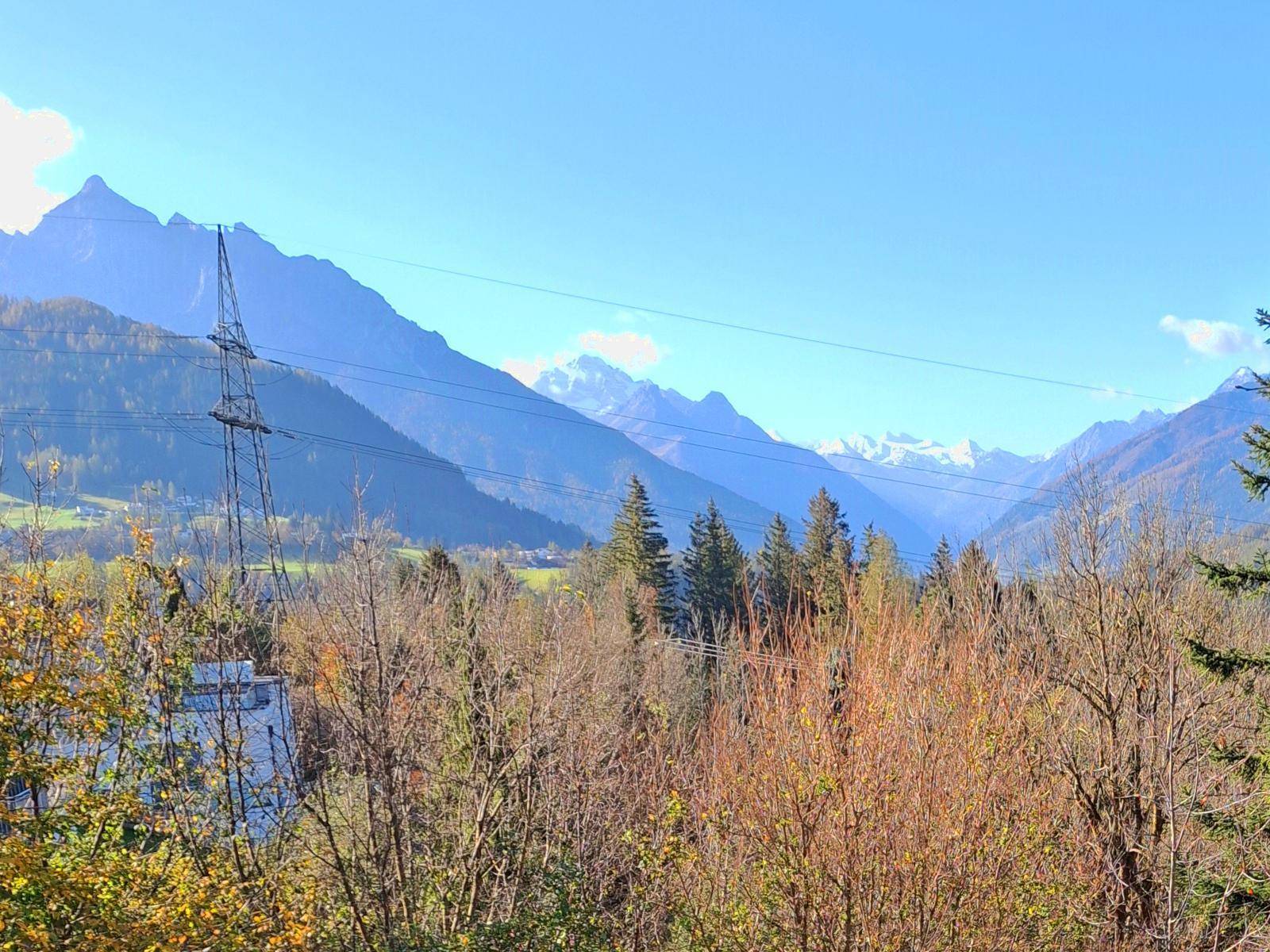 Weitläufiger Blick auf die majestätischen Berge, umgeben von Bäumen und einer Stromleitung.
