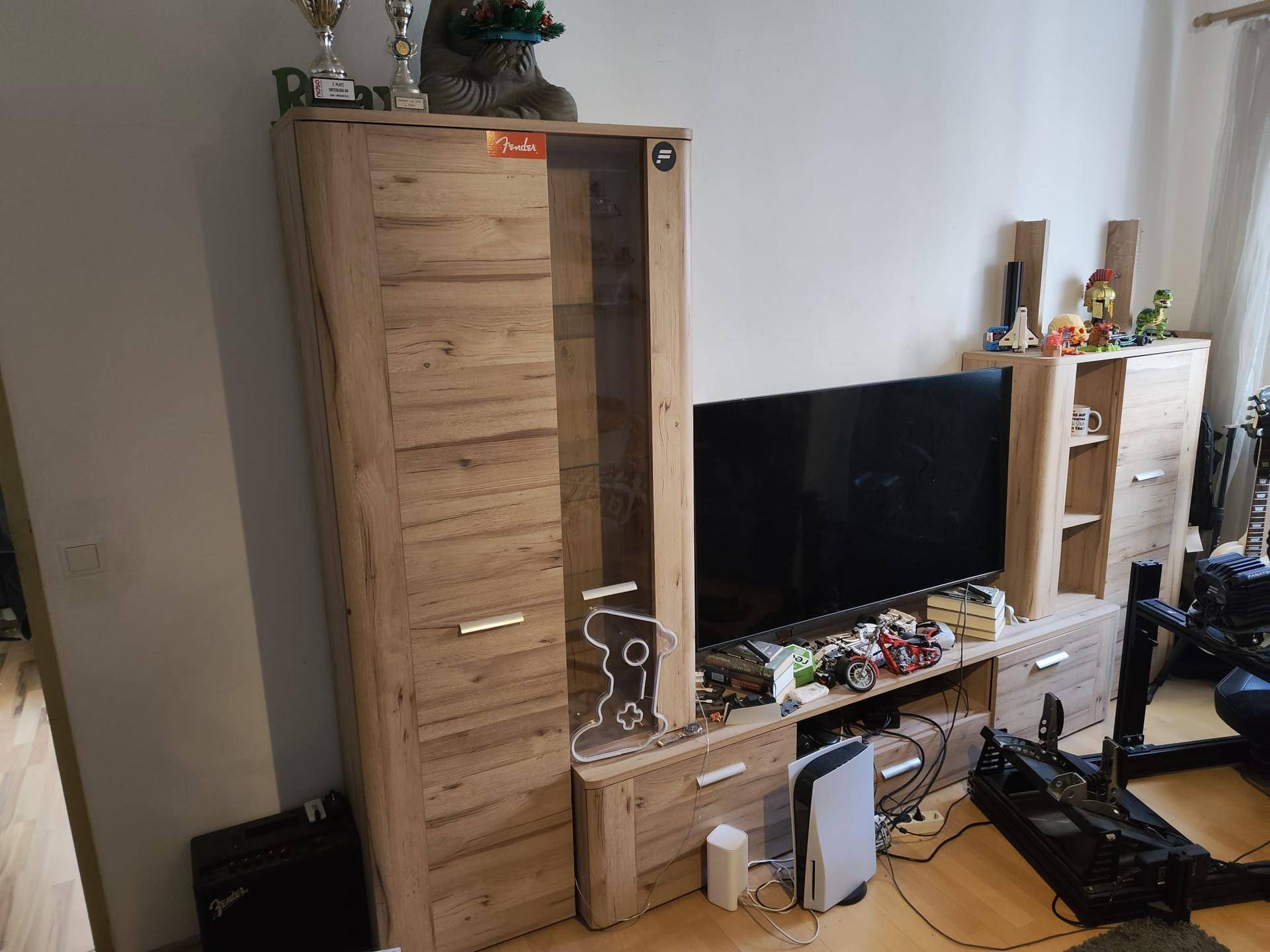 Wohnzimmerbereich mit moderner TV-Möbelwand aus Holz und persönlicher Dekoration.