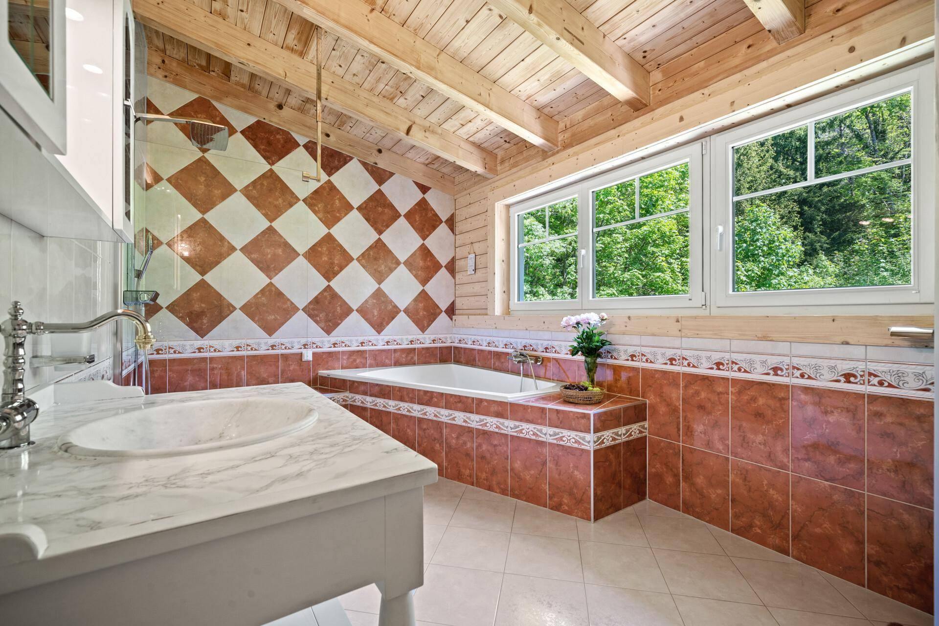 Geräumiges Badezimmer mit Badewanne, Einzelwaschbecken und auffälligen Fliesen.