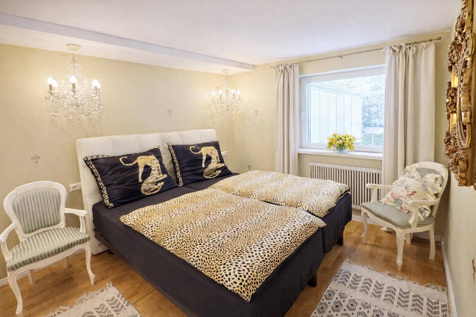 Schlafzimmer mit bequemen Betten, dekorativen Kronleuchtern und viel natürlichem Licht.