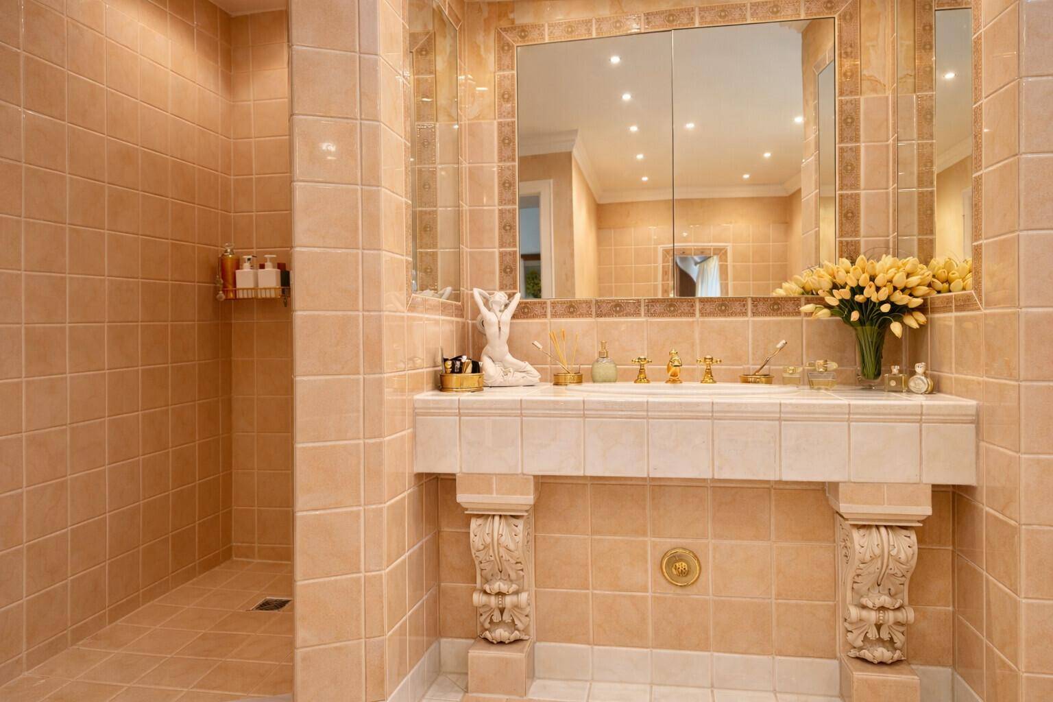 Geräumiges Badezimmer mit begehbarer Dusche, stilvollem Waschtisch und beigefarbenen Fliesen.