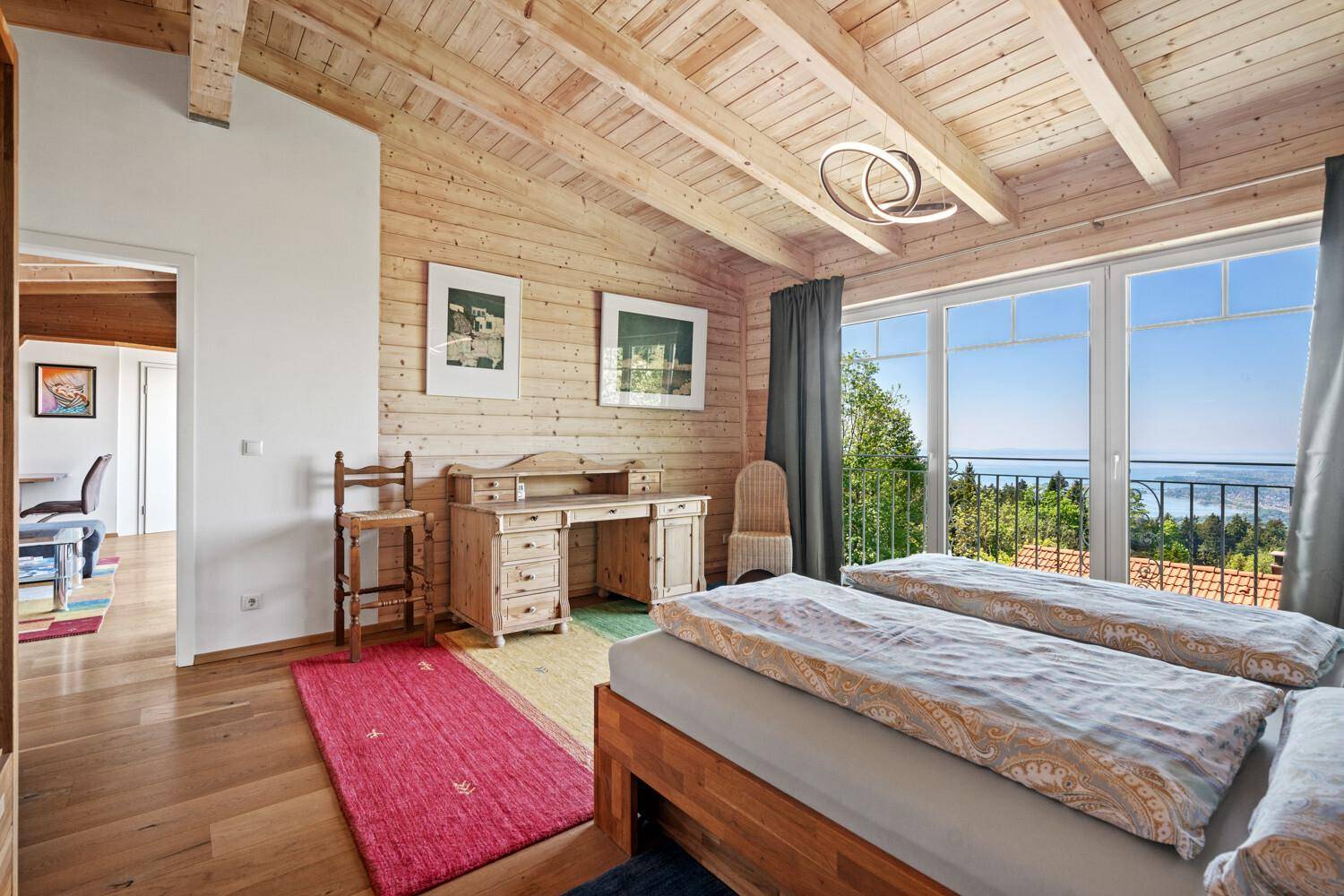 Helles Schlafzimmer mit zwei Einzelbetten, Holzboden und weitem Ausblick.