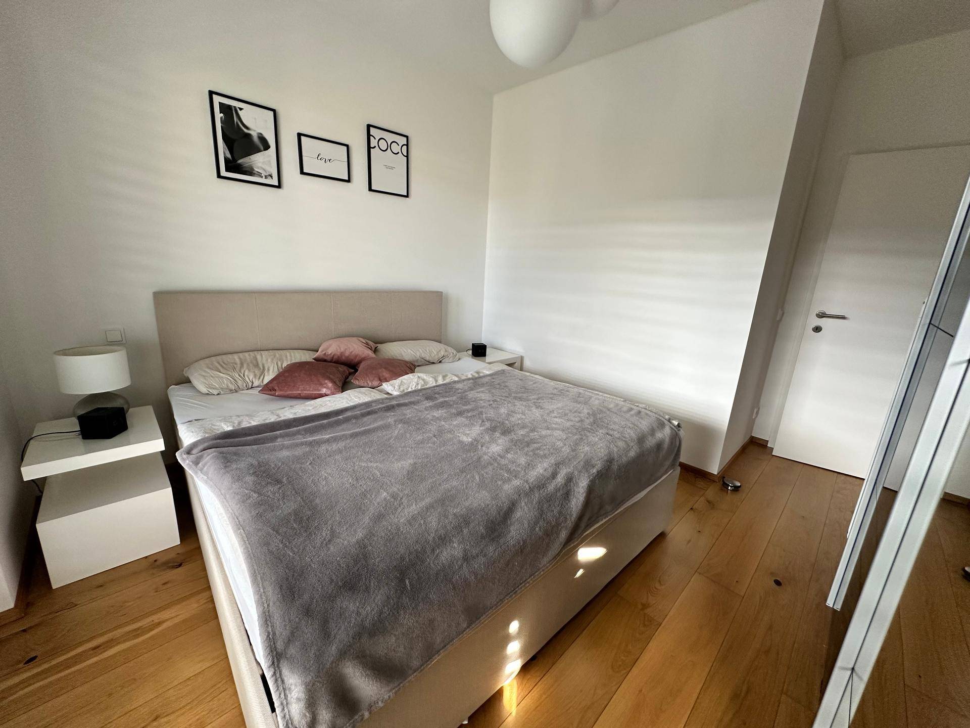 Gemütliches Schlafzimmer mit Doppelbett, Nachttischen und warmem Holzboden.