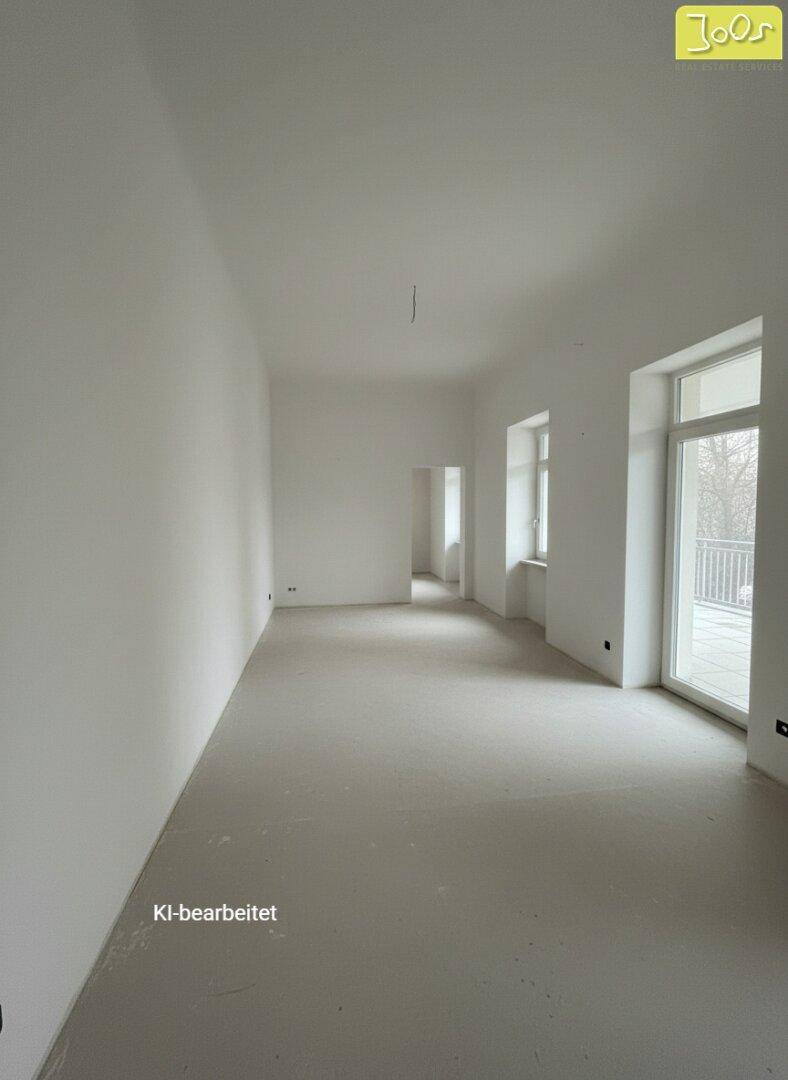 Heller, unmöblierter Raum mit weißen Wänden und Zugang zu einem Balkon oder einer Terrasse.