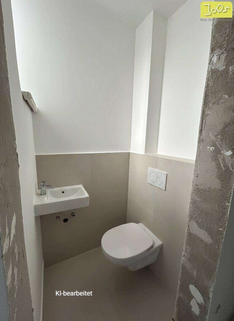 Kleines Gäste-WC mit wandhängender Toilette und modernem Waschbecken, halbhoch gefliest.