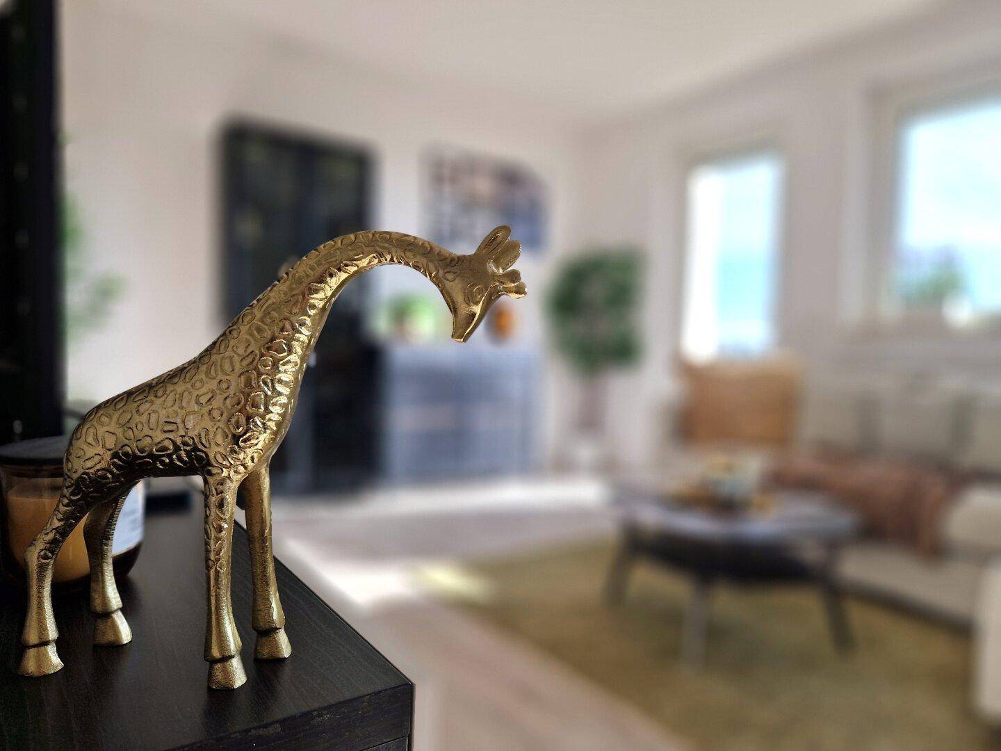 Dekorative goldene Giraffenfigur auf einem Sideboard im modernen Wohnzimmer.