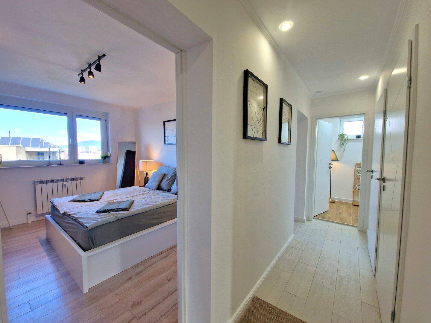 Heller Flur mit Übergang zum Schlafzimmer und Badezimmer, modern und funktional.