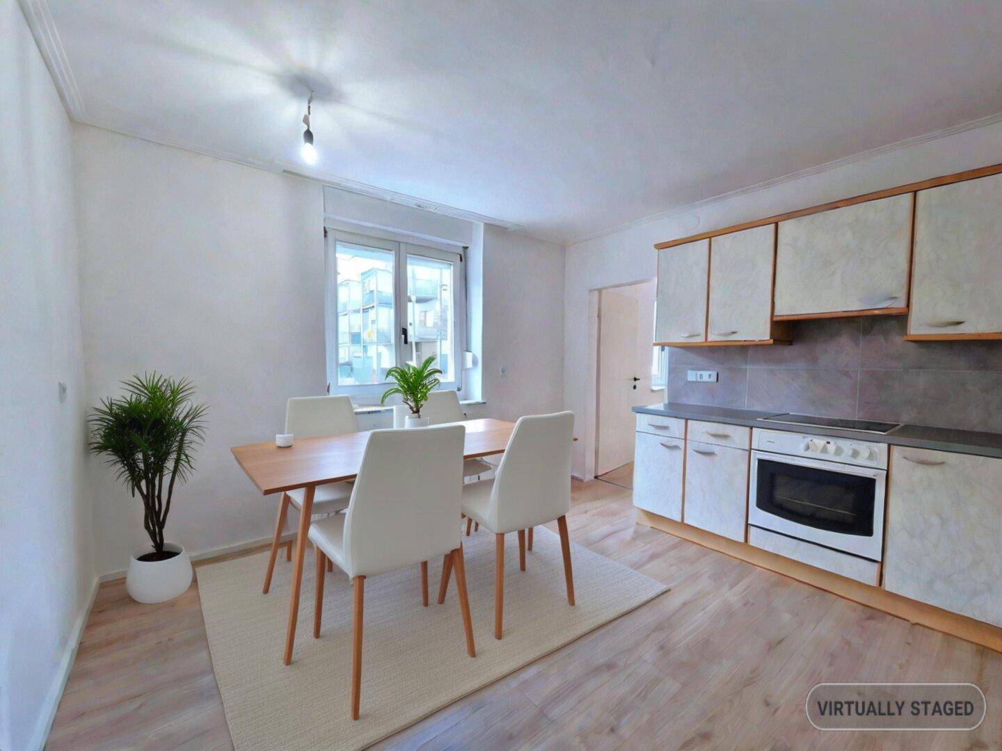 Virtuell inszenierte Küche mit Essbereich, hellen Schränken, Ofen und Fenster.