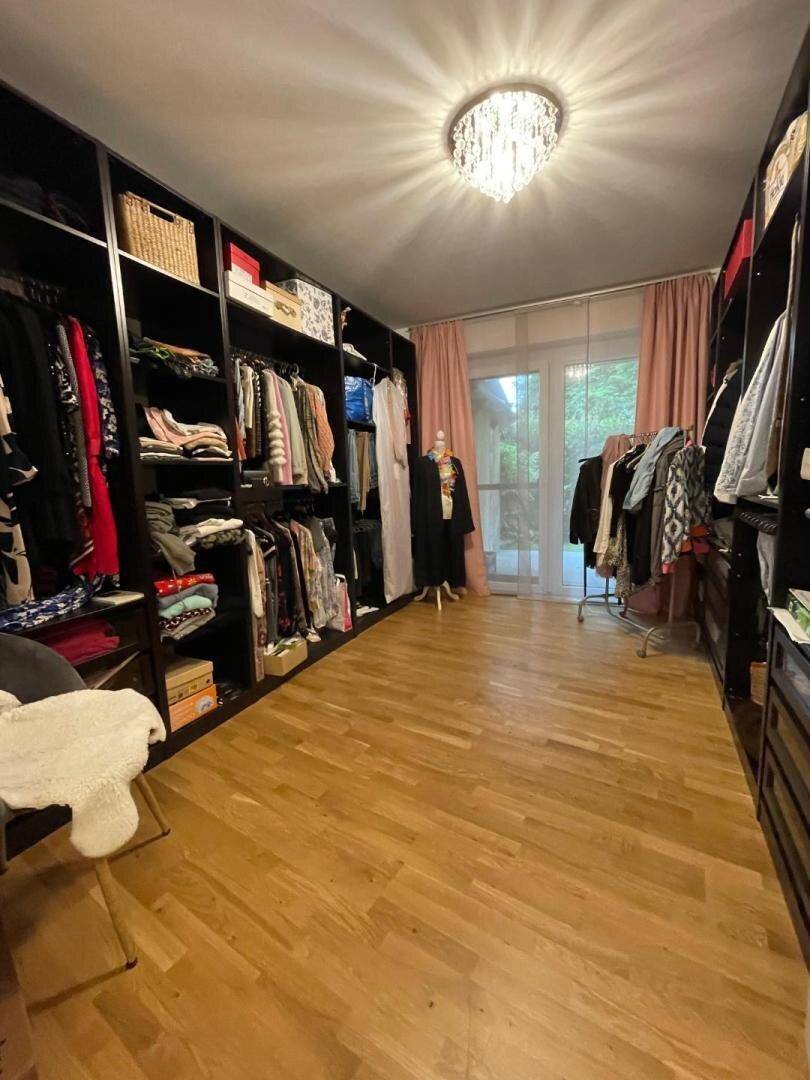 Geräumiger begehbarer Kleiderschrank mit viel Stauraum und direktem Zugang zum Außenbereich.