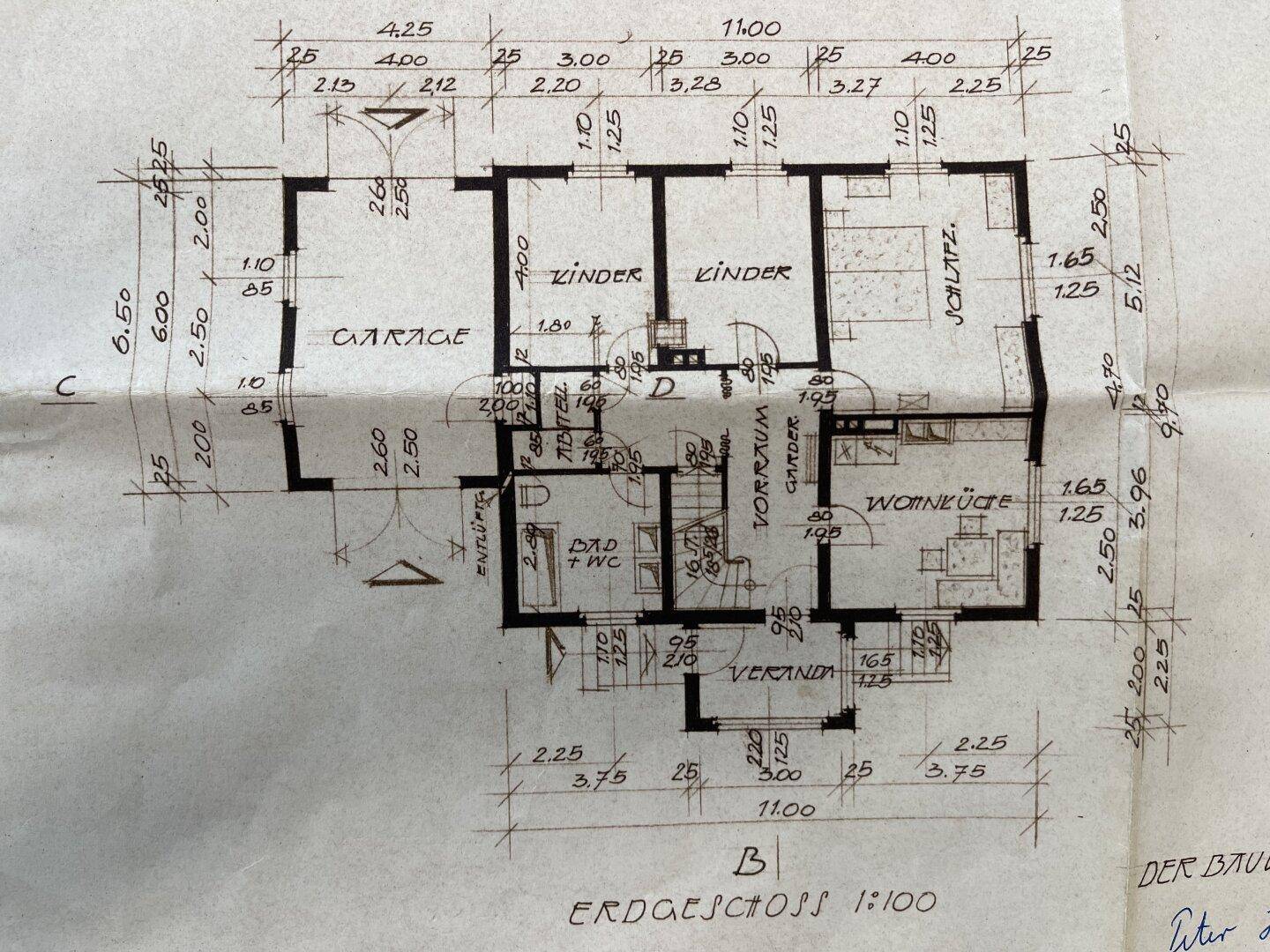 Grundriss des Erdgeschosses mit Wohnküche, Kinderzimmern, Garage und Veranda.