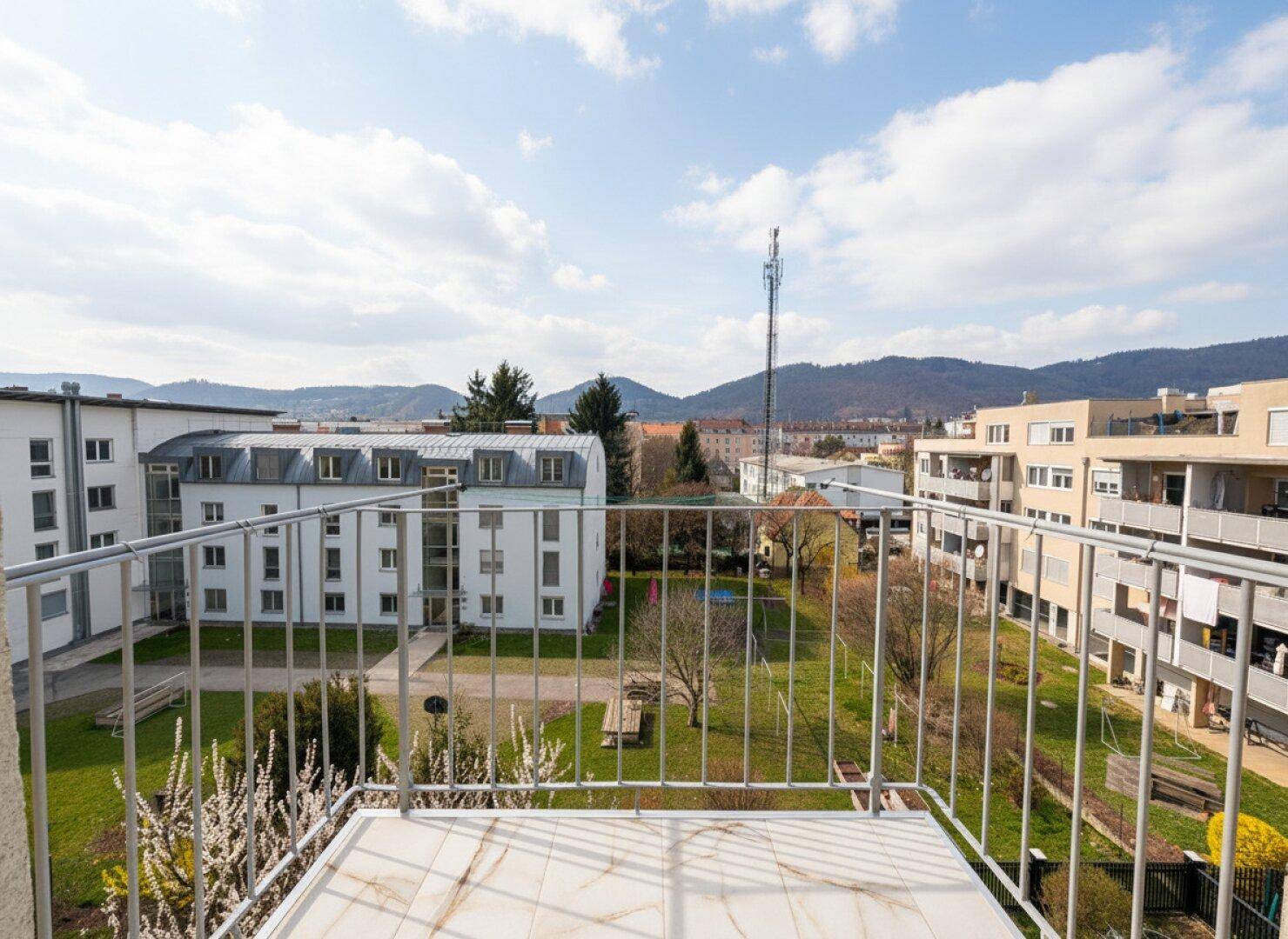Balkon mit weitem Blick über die Wohngegend und die umliegende Landschaft.