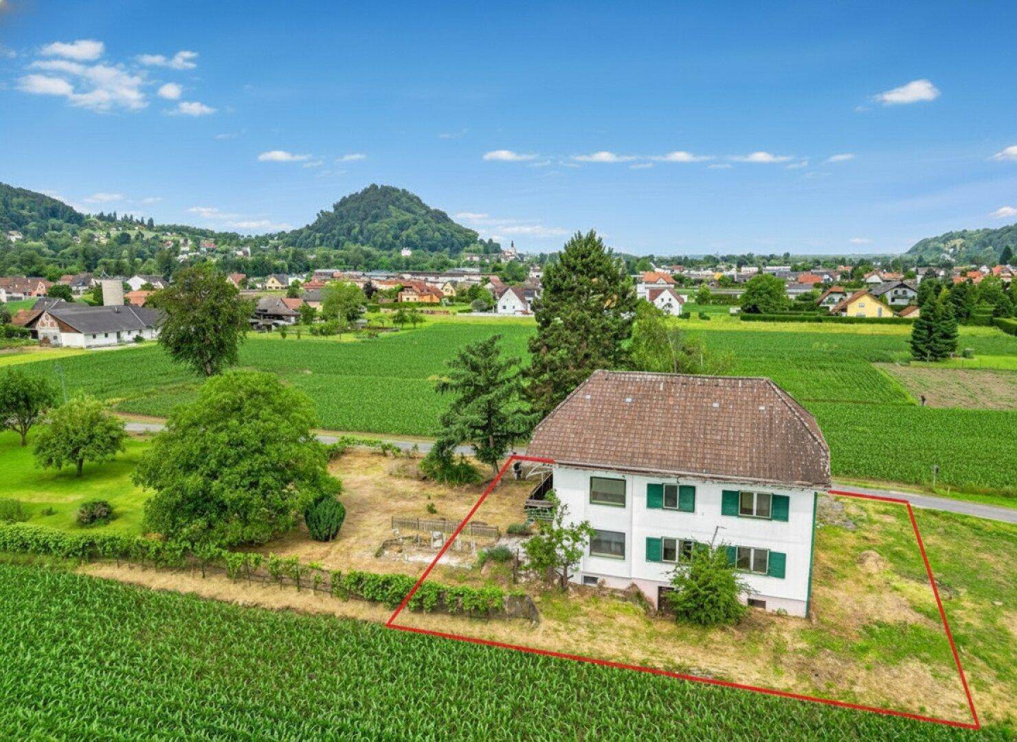 Luftaufnahme des Hauses in ländlicher Lage mit weitem Blick auf die umliegende Landschaft und Berge.