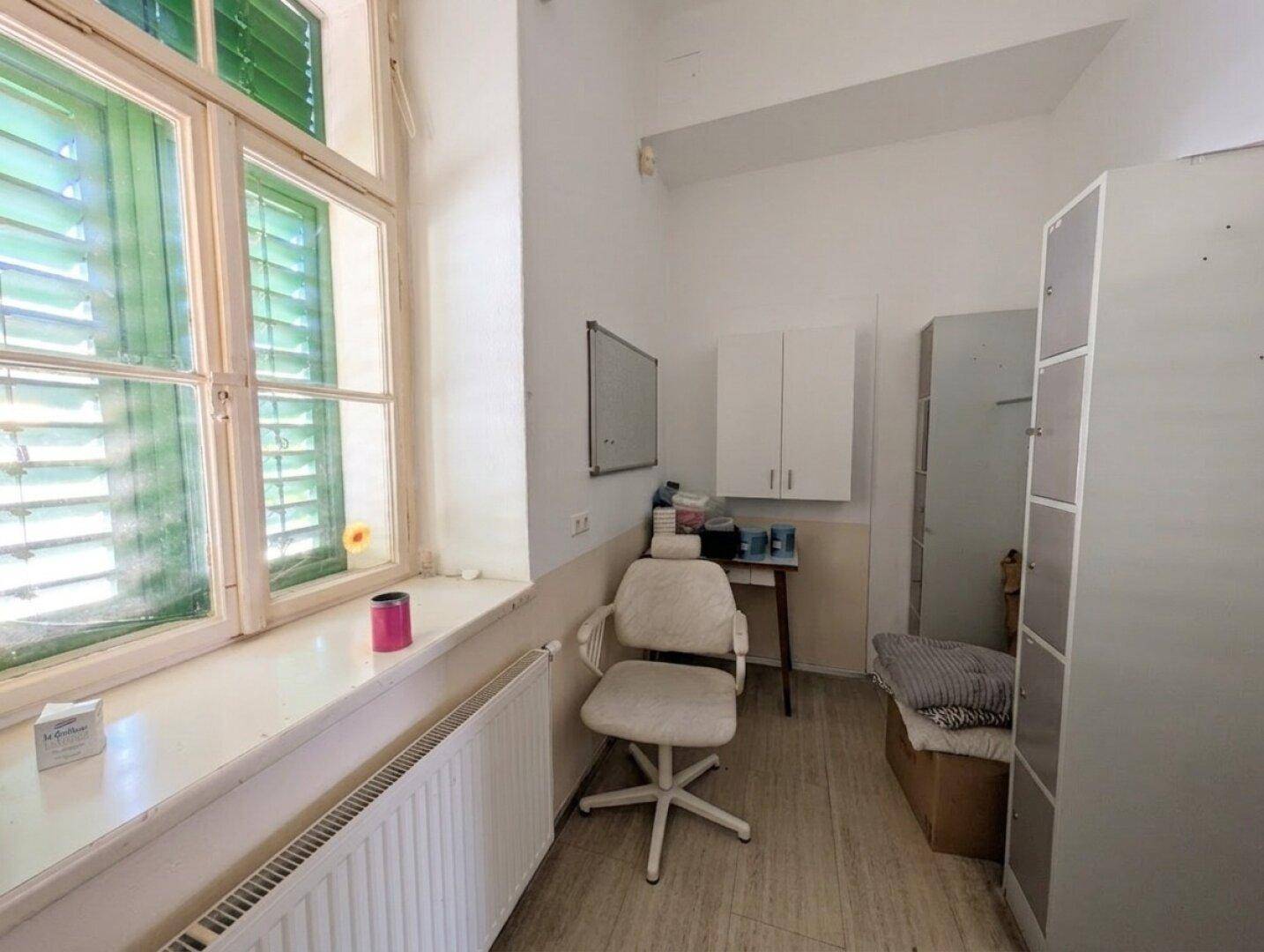 Lagerraum mit Fenster, Heizung und verschiedenen Schränken, ideal für Vorräte und Arbeitsmaterialien.