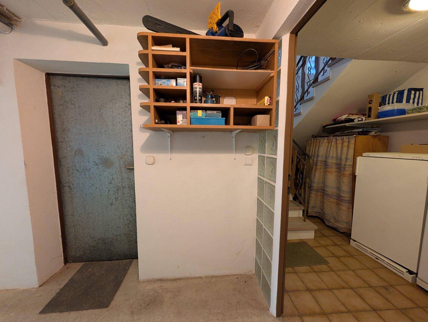 Kellerbereich mit Lagerregal und Zugang zu weiteren Räumen, funktional gestaltet.