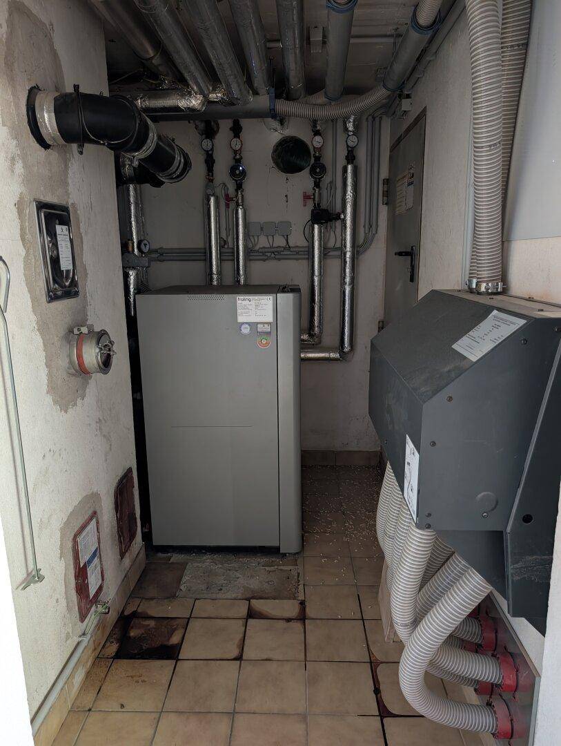 Heizungsraum mit moderner Heizungsanlage und sichtbaren Rohrleitungen.