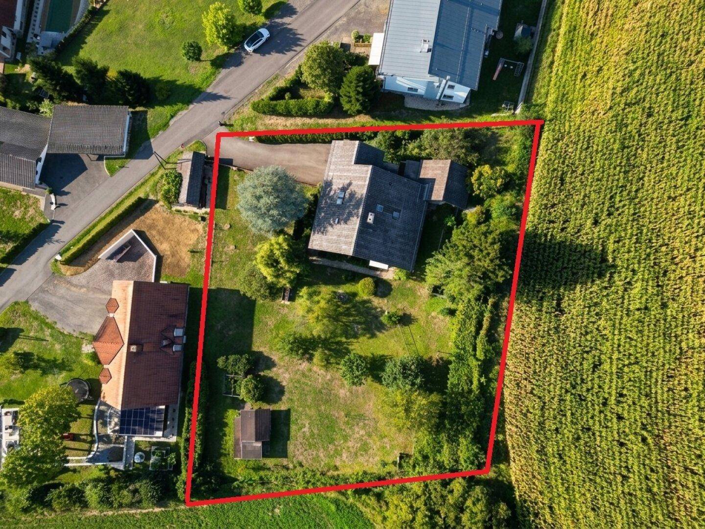 Draufsicht des Grundstücks mit angrenzenden Feldern und Zufahrtsstraße in ländlicher Umgebung.