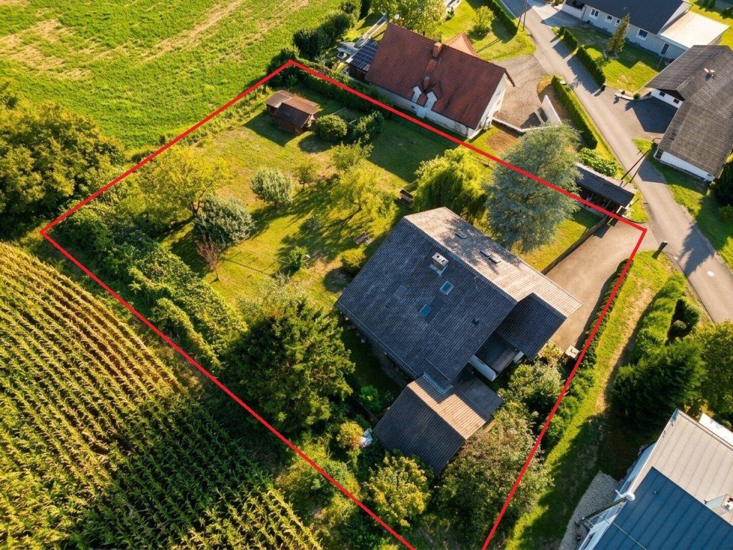 Vogelperspektive eines Hauses mit weitläufigem Garten und angrenzenden Feldern.