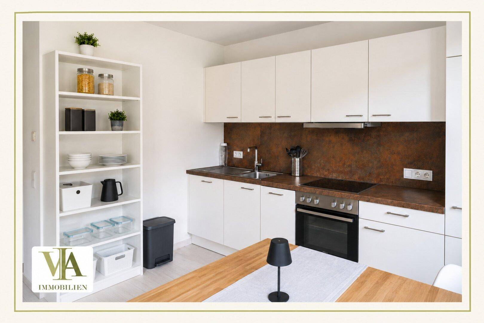 Moderne Küche mit weißen Schränken, brauner Arbeitsplatte und integrierten Geräten.