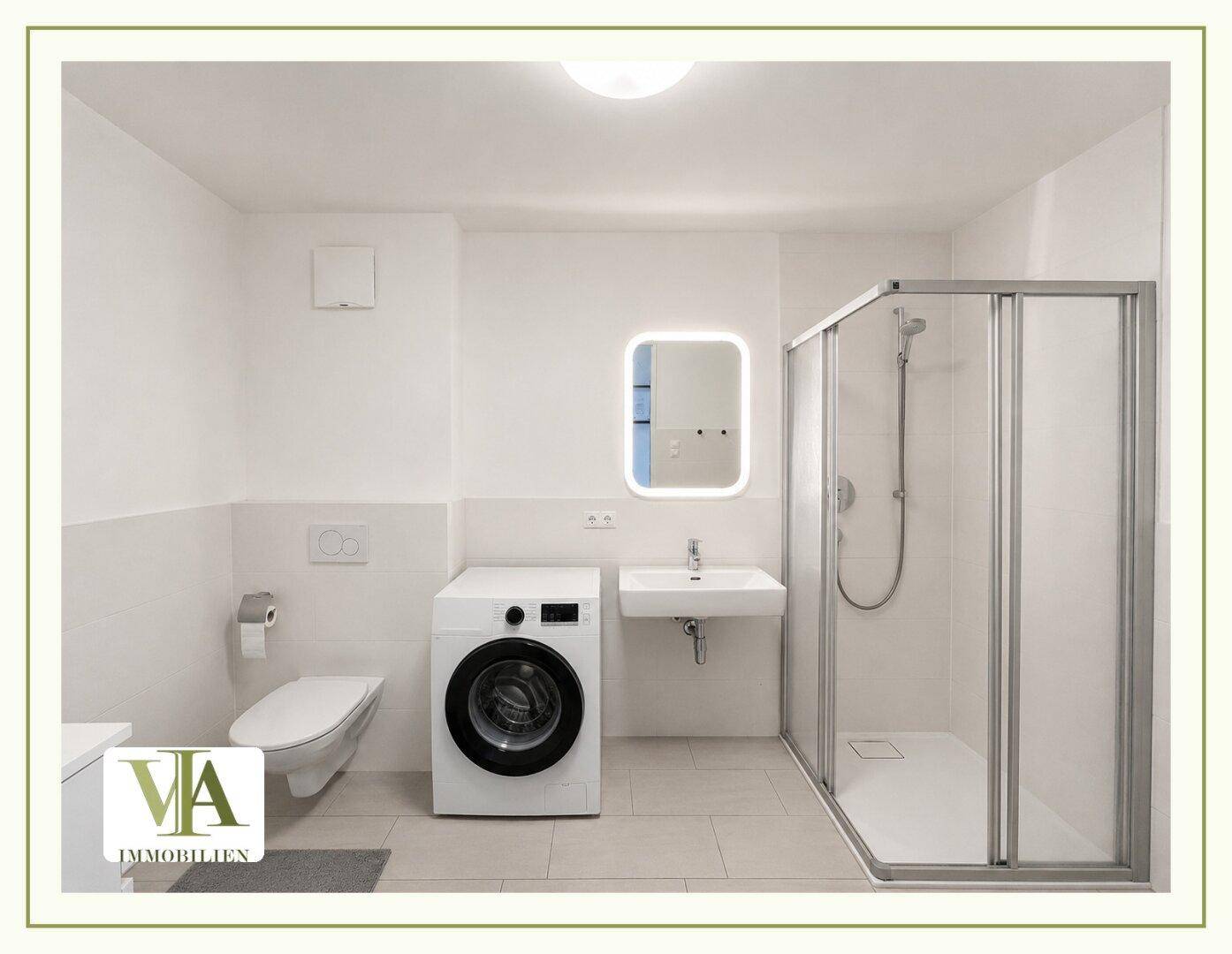 Modernes Badezimmer mit Dusche, Waschbecken, Toilette und integrierter Waschmaschine.