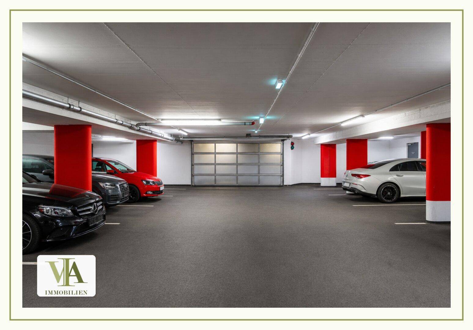 Geräumige Tiefgarage mit mehreren Stellplätzen und roter Säulenakzentuierung.