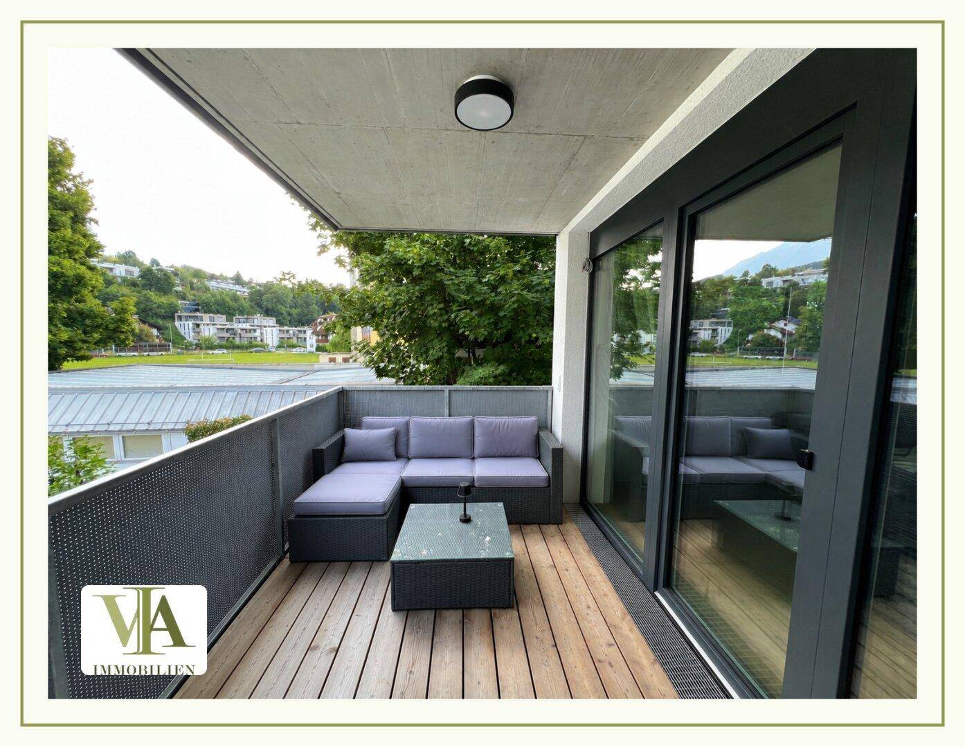 Gemütlicher Balkon mit Loungemöbeln und Holzboden, ideal zum Entspannen im Freien.