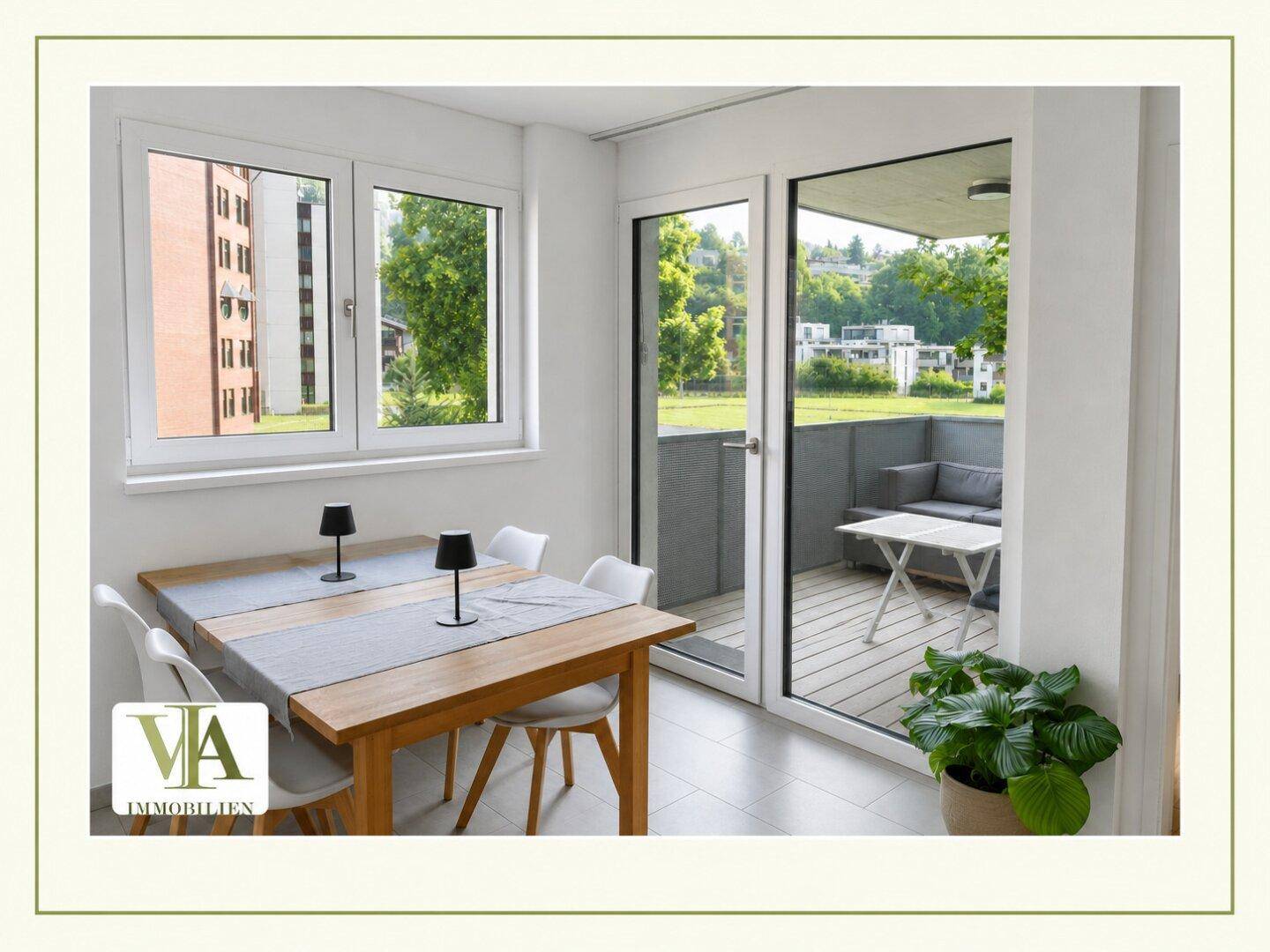 Heller Essbereich mit Holztisch, weißen Stühlen und Zugang zu einem möblierten Balkon.