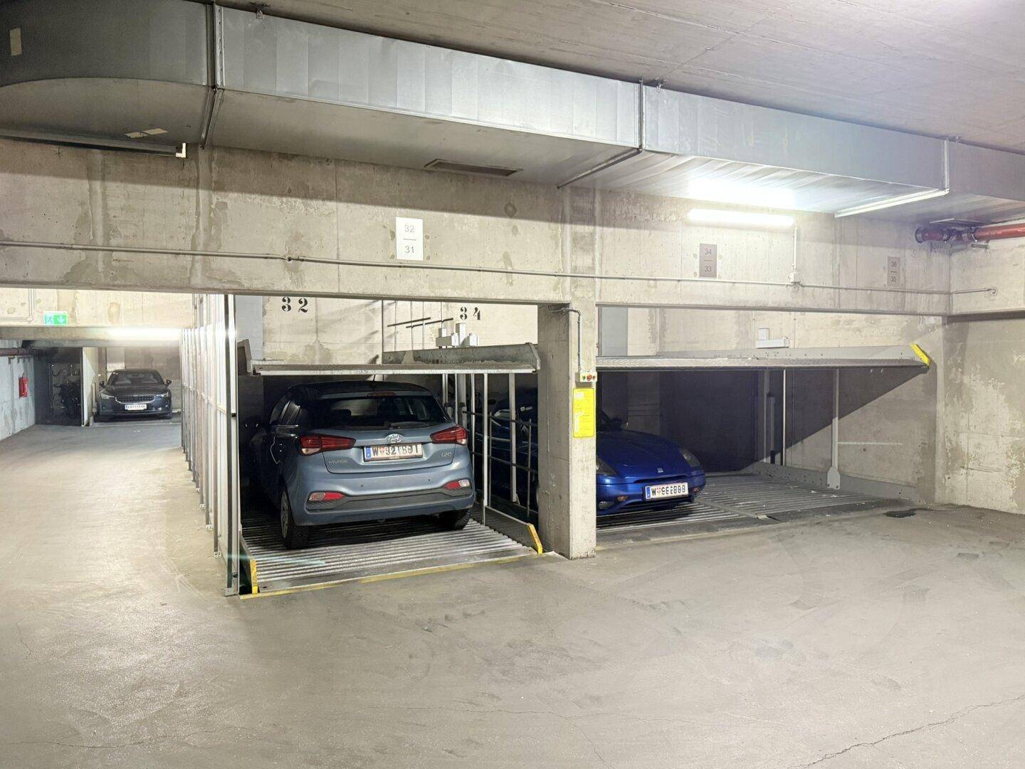 Autos auf mehreren Ebenen von Doppelparkern in einer modernen Tiefgarage.