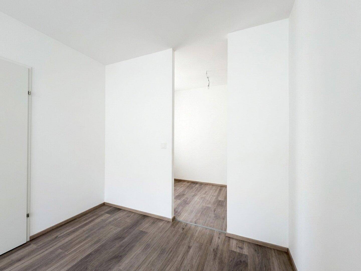 Heller Flurbereich mit Laminatboden, der zu weiteren Zimmern der Wohnung führt.