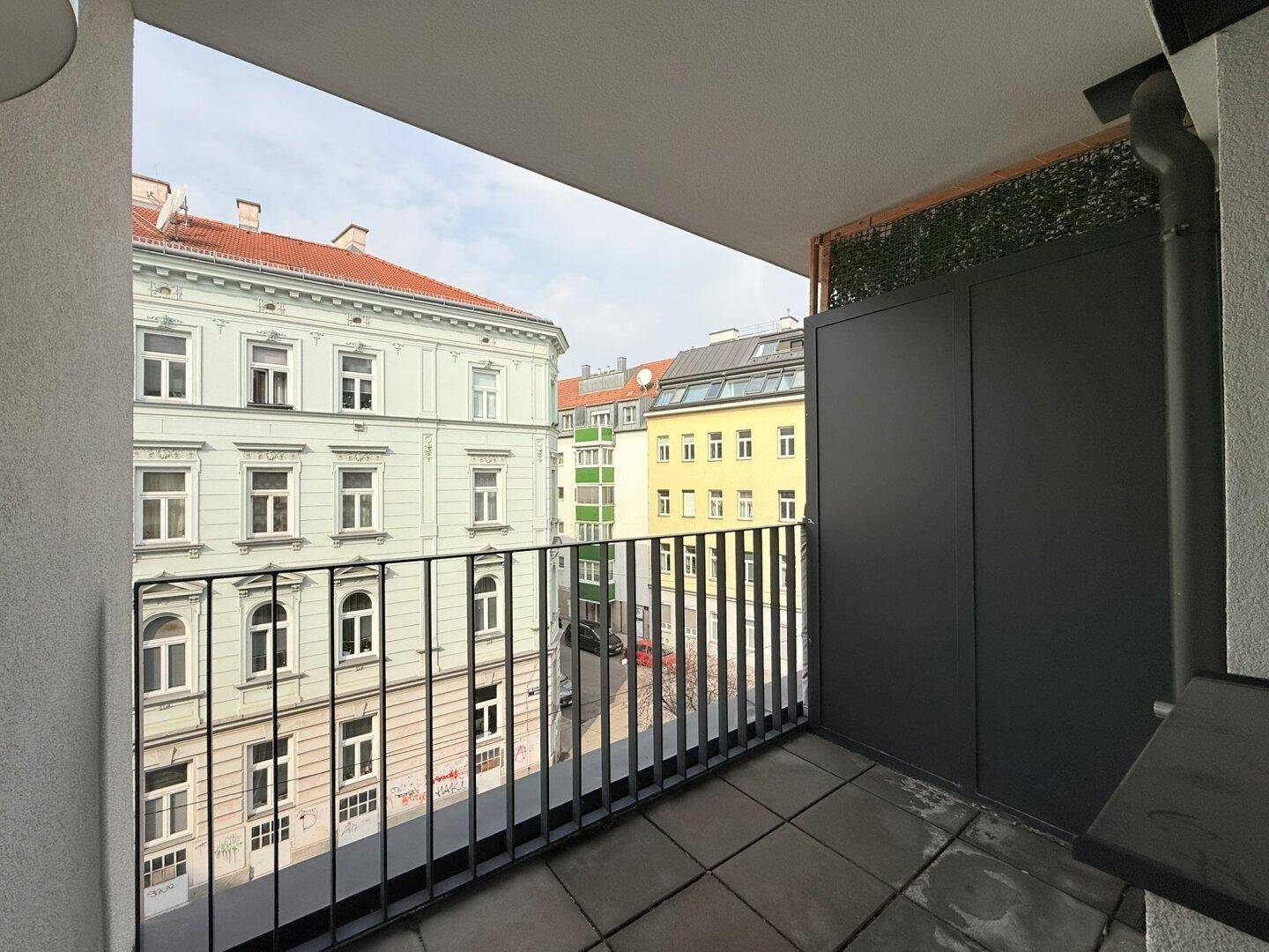 Geräumiger Balkon mit Blick auf die umliegenden Gebäude und die städtische Umgebung.