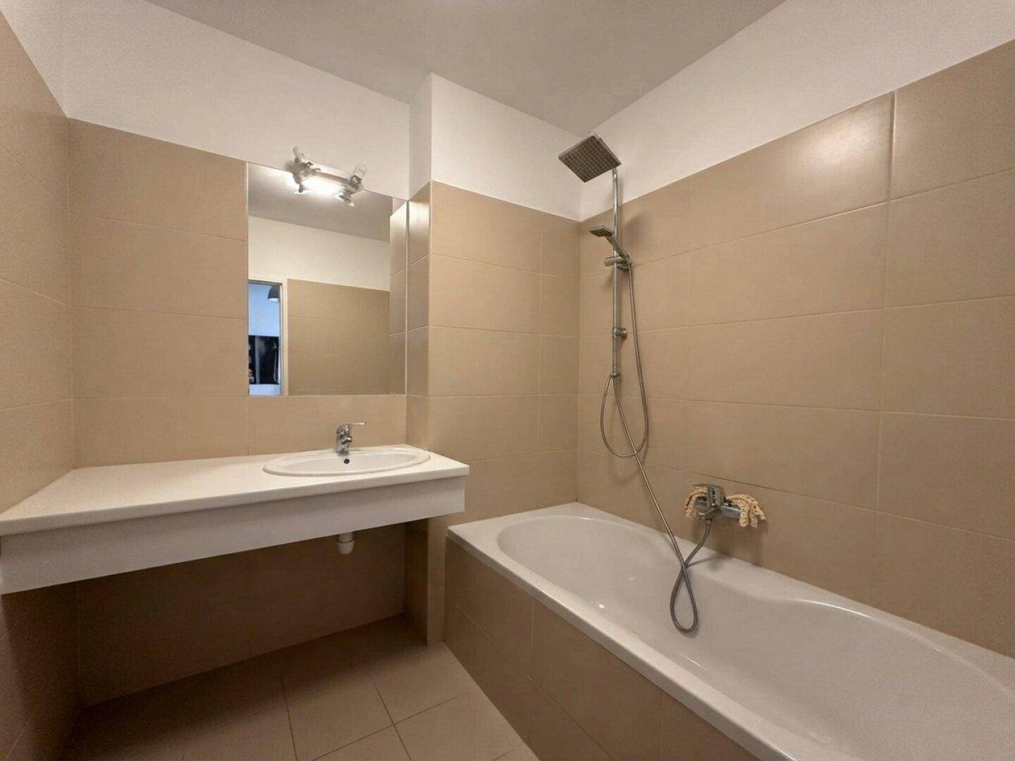 Modernes Badezimmer mit Badewanne, Dusche und großem Waschbecken mit Spiegel.
