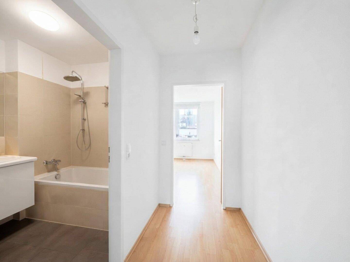 Heller Flur mit Parkettboden, der zu einem Badezimmer und weiteren Räumen führt.