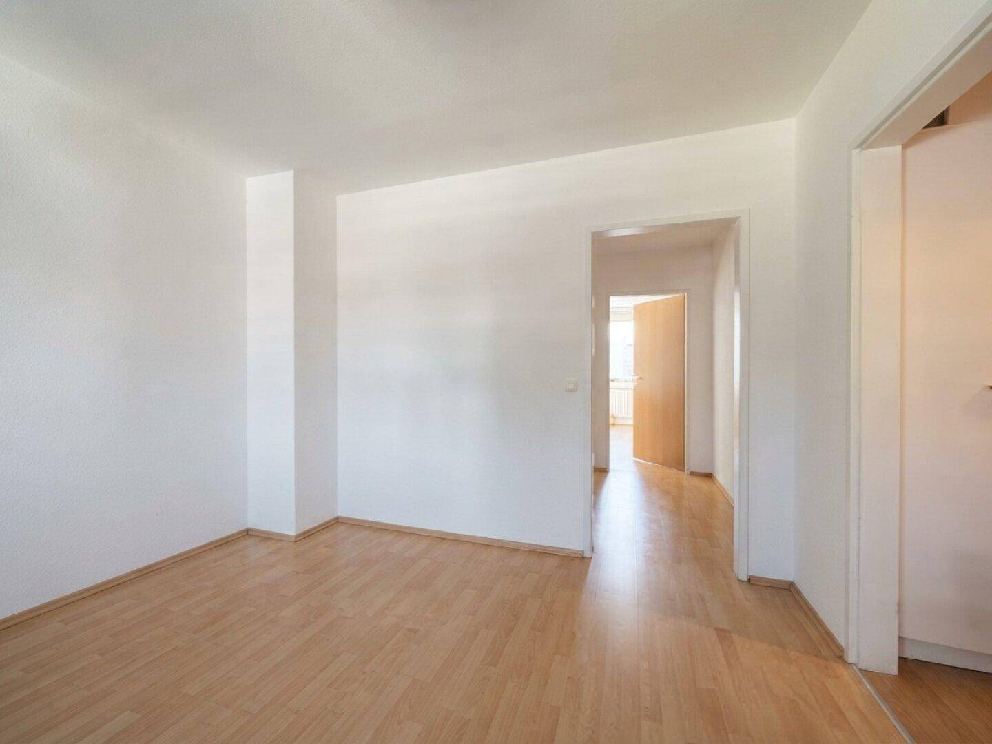 Heller Flur mit Parkettboden, der zu weiteren Zimmern führt.